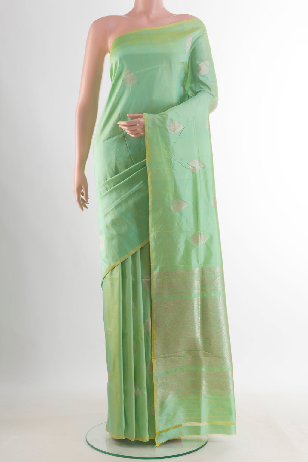 Pure Silk Pista Green Banarasi Katan Saree with Zari Butta on the body and Without Border.  displayed on a mannequin