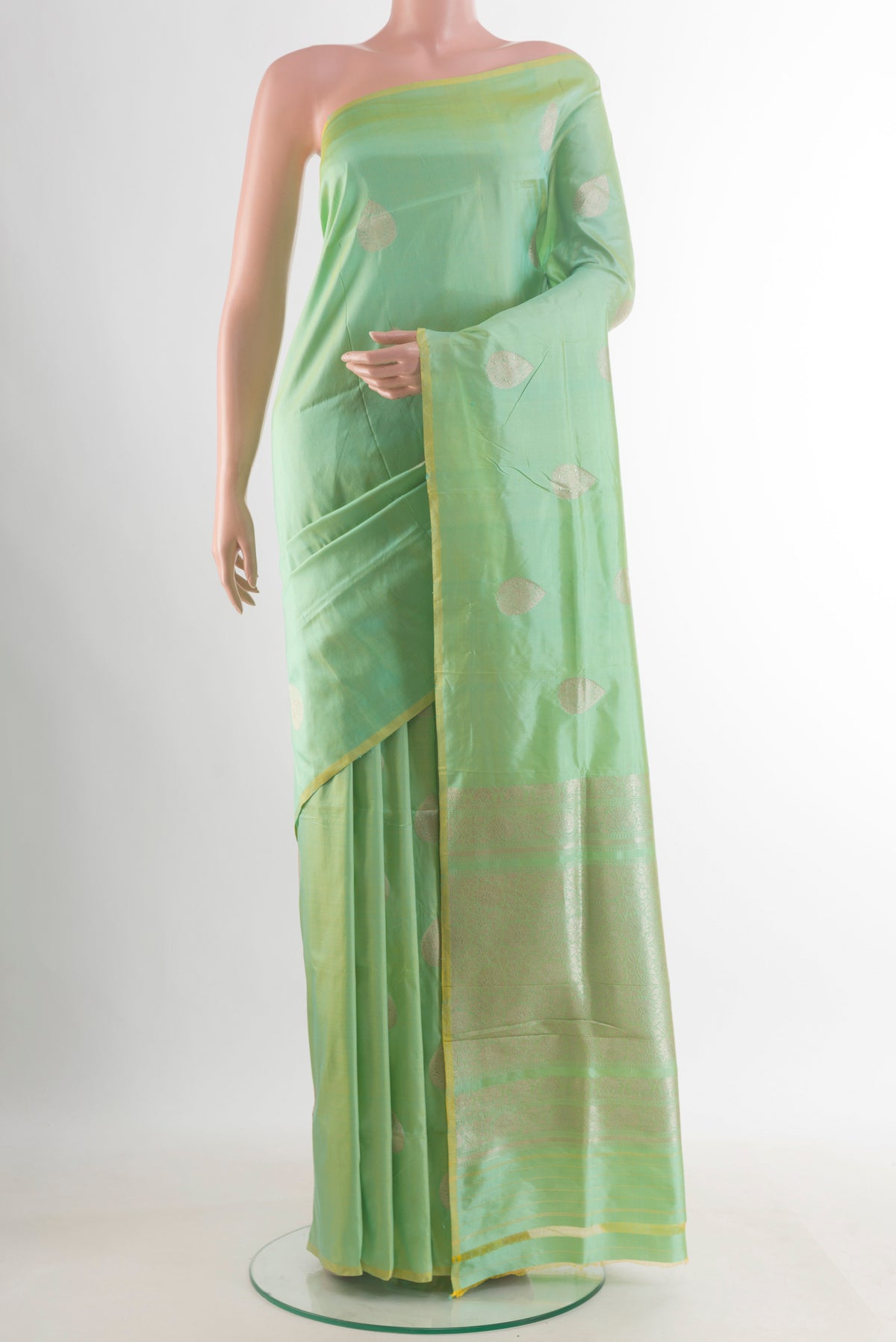 Pure Silk Pista Green Banarasi Katan Saree with Zari Butta on the body and Without Border.  displayed on a mannequin