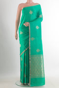 Green Banarasi Saree with Zari Butta on the body and Zari Border.  displayed on a mannequin
