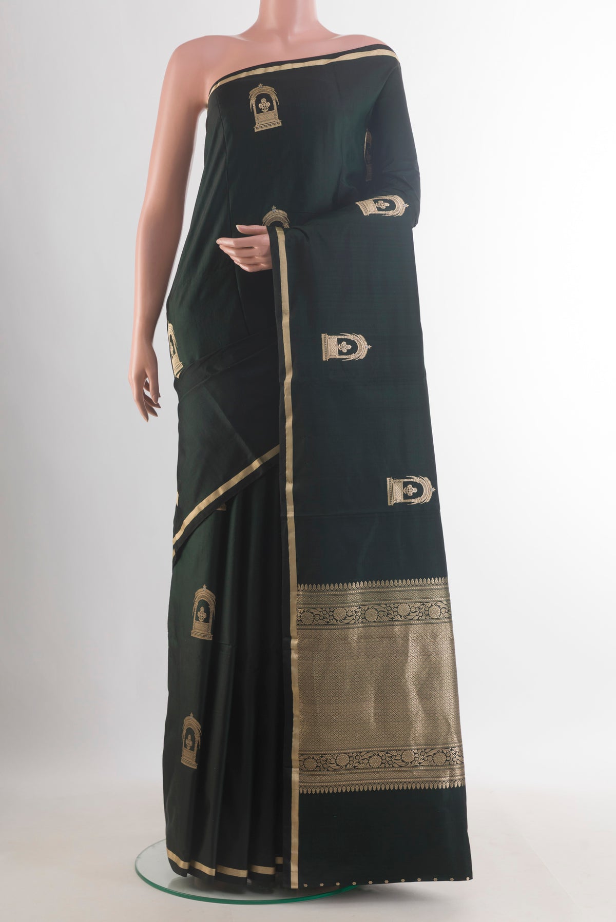 Bottle Green Banarasi Saree with Zari Butta on the body and Zari Border.  displayed on a mannequin