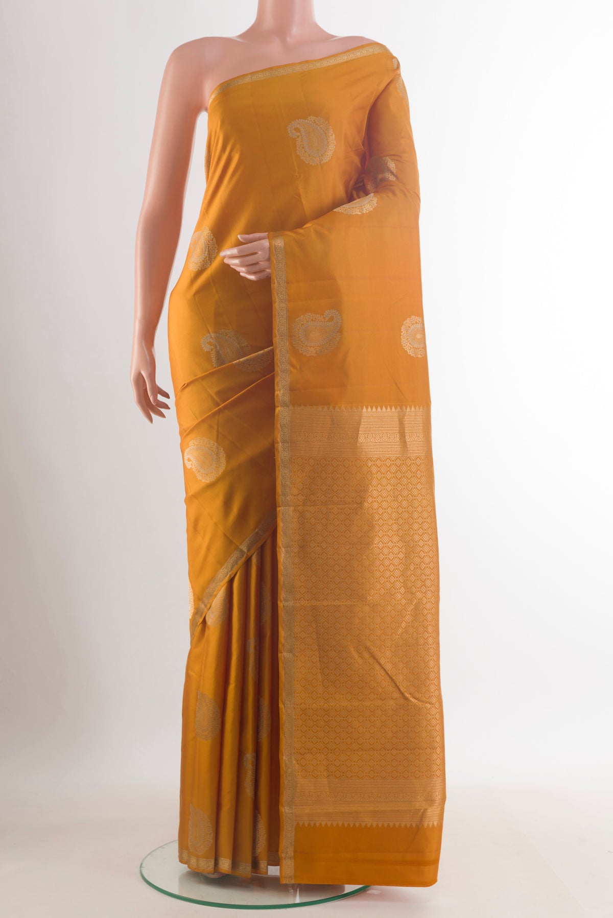 Pure Silk Mustard Kanchipuram Saree with Zari Butta on the body and Zari Border.  displayed on a mannequin