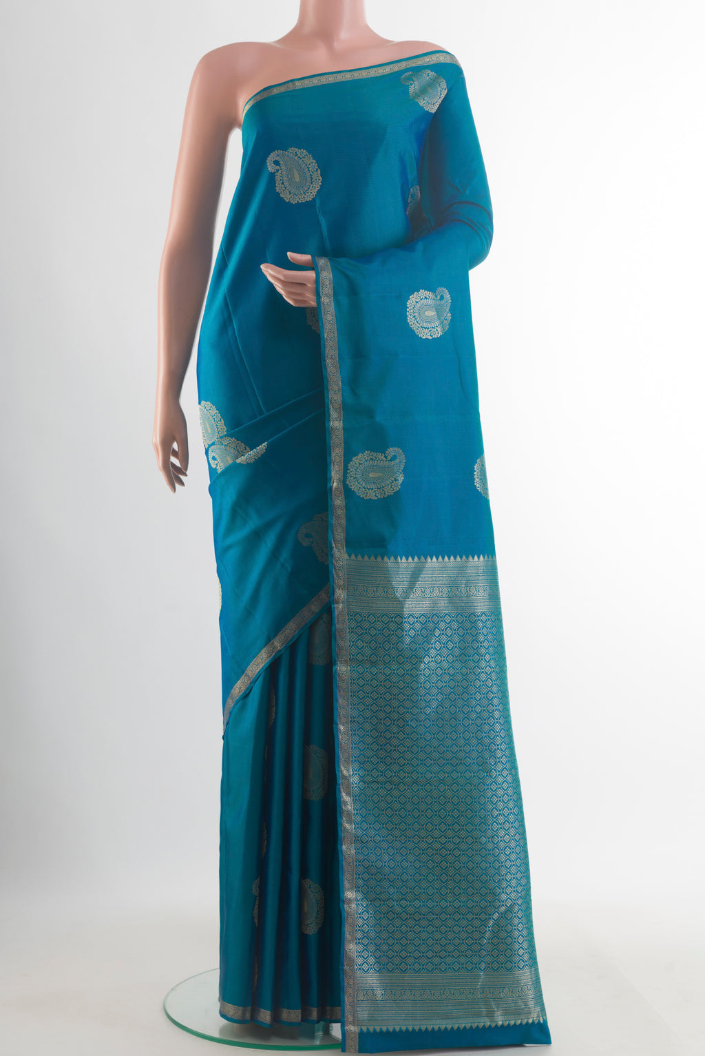 Pure Silk Blue Kanchipuram Saree with Zari Butta on the body and Zari Border.  displayed on a mannequin