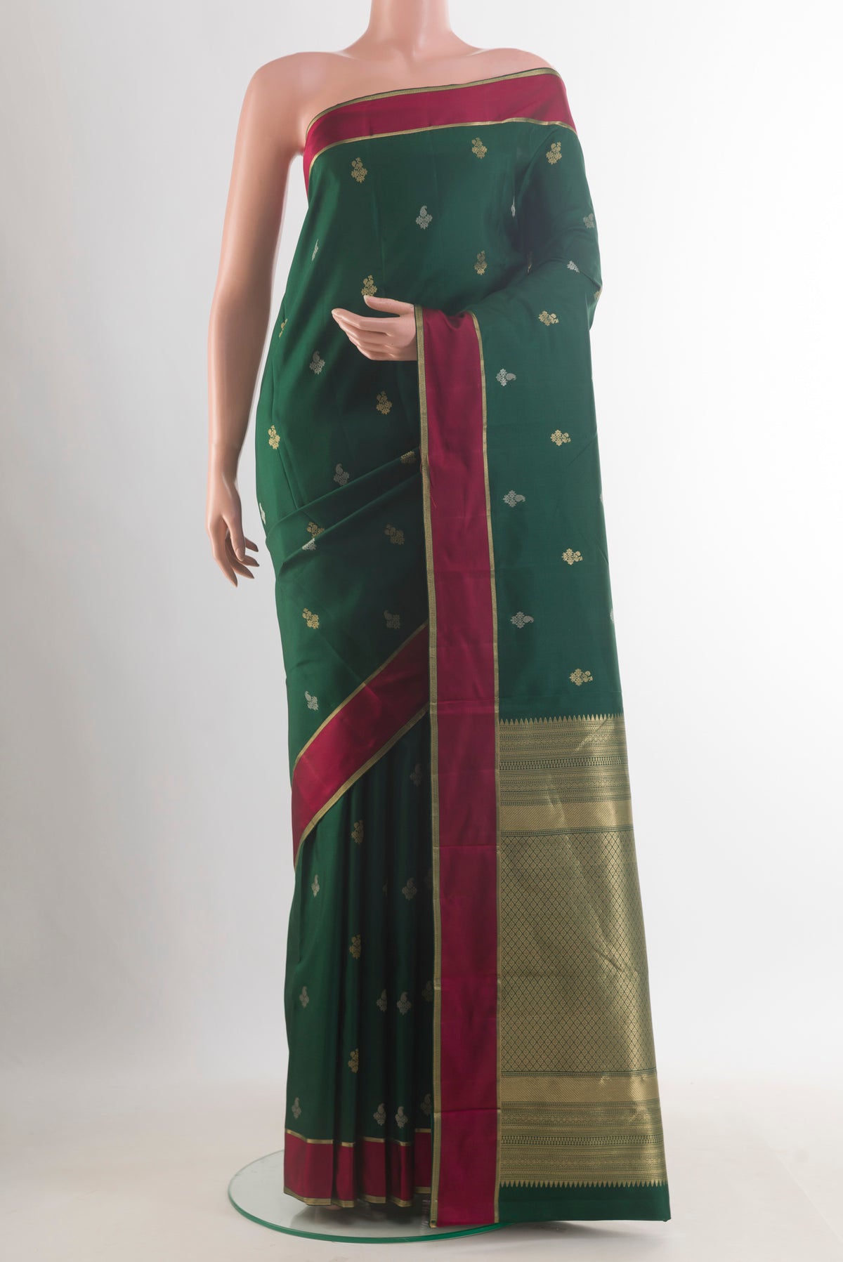 Pure Silk Bottle Green Kanjivaram Saree with Zari Butta on the body and Plain Border.  displayed on a mannequin