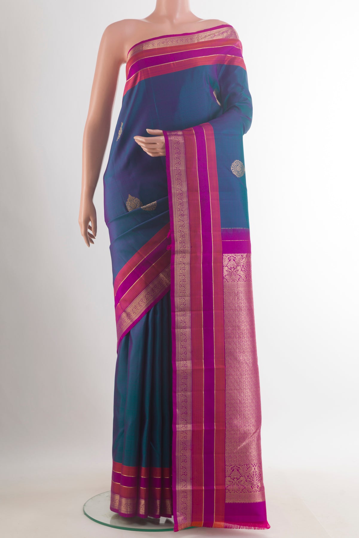 Pure Silk Peacock Blue Kanchipuram Saree with Zari Butta on the body and Zari Border.  displayed on a mannequin