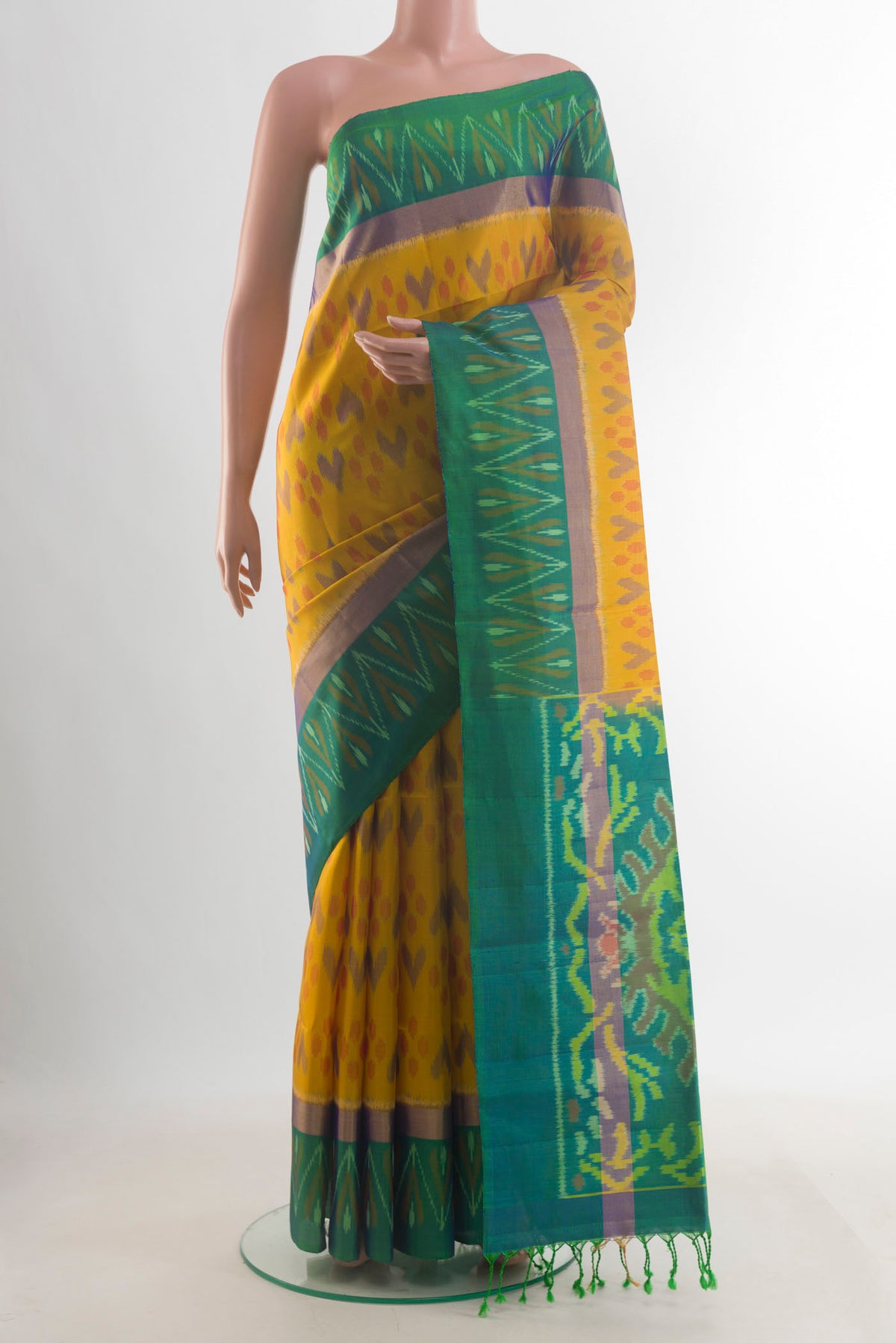 Pure Silk Mustard Soft Saree with Ikat design on the body and Zari Border.  displayed on a mannequin