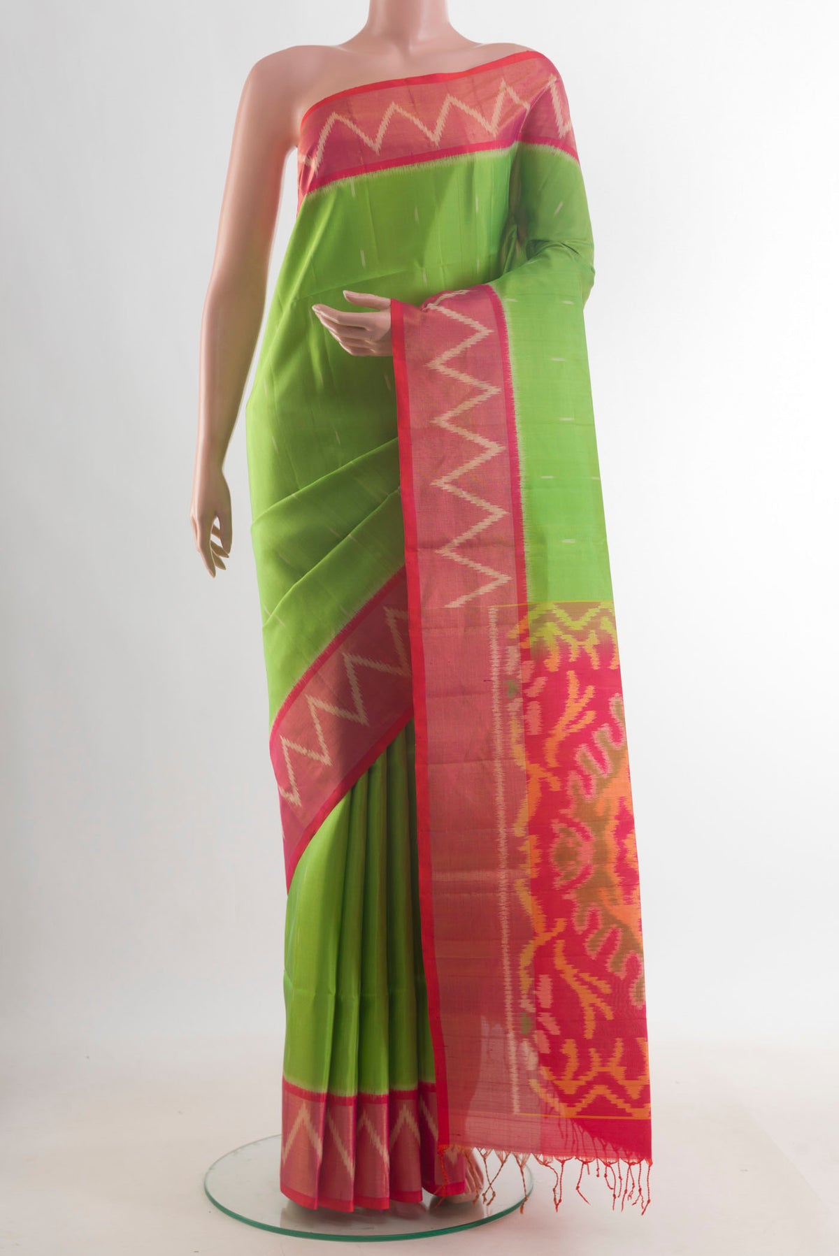 Pure Silk Parrot Green Soft Saree with Ikat design on the body and Zari Border.  displayed on a mannequin