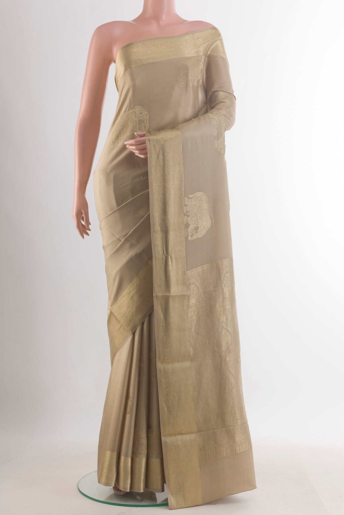 Beige Mysore Crepe Saree with Zari Butta on the body and Zari Border.  displayed on a mannequin