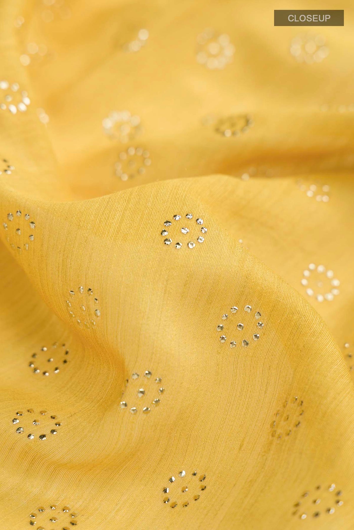 Close up of Yellow Bhagalpuri Tussar Silk Saree with Embroidery on the body and Zari Border displaying folds