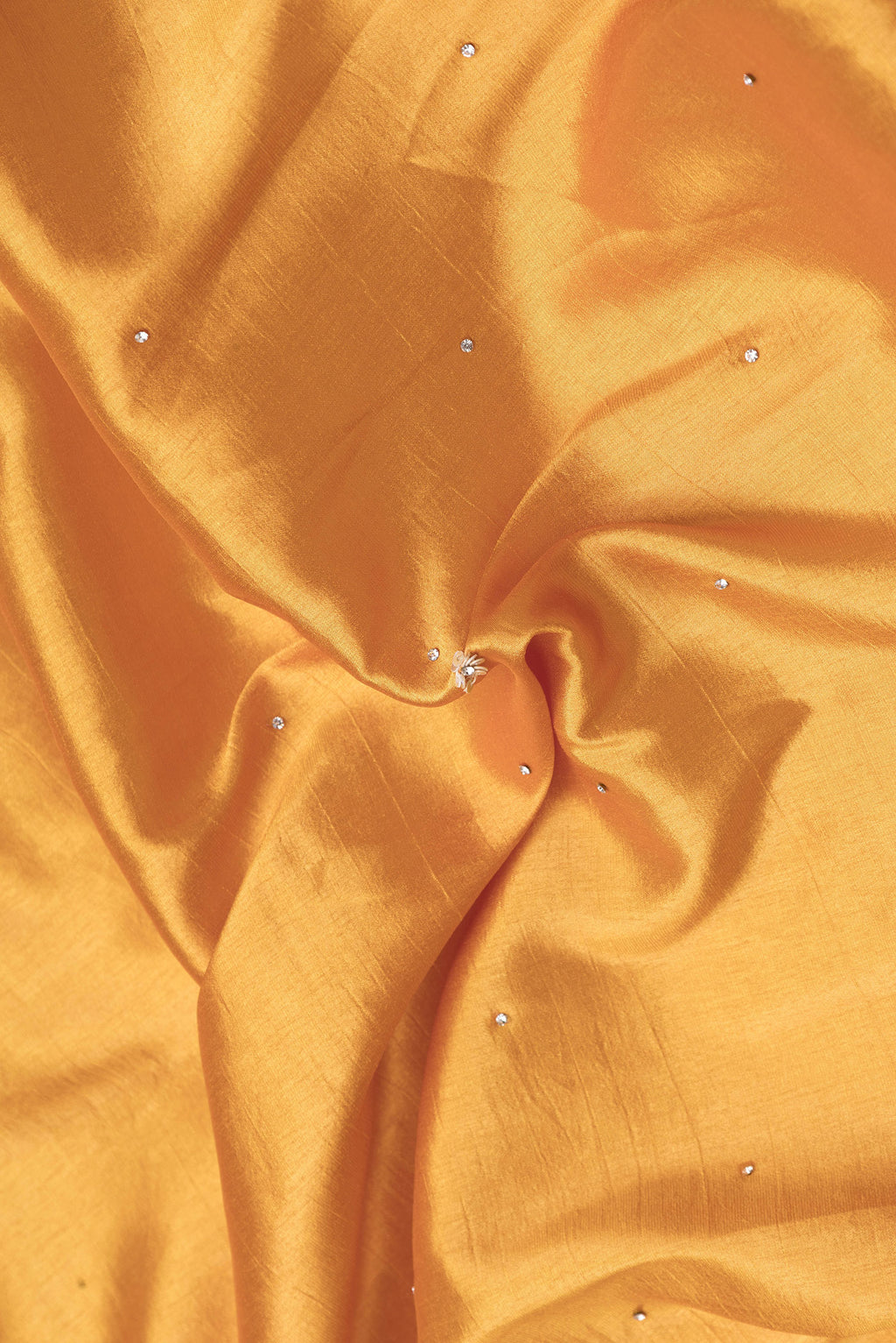 Close up of Gold Dual Tone Mysore Crepe Saree with Embroidery on the body and Embroidery Border.  displaying folds