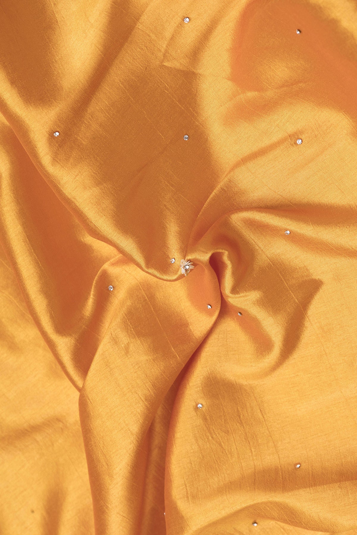 Close up of Gold Dual Tone Mysore Crepe Saree with Embroidery on the body and Embroidery Border.  displaying folds