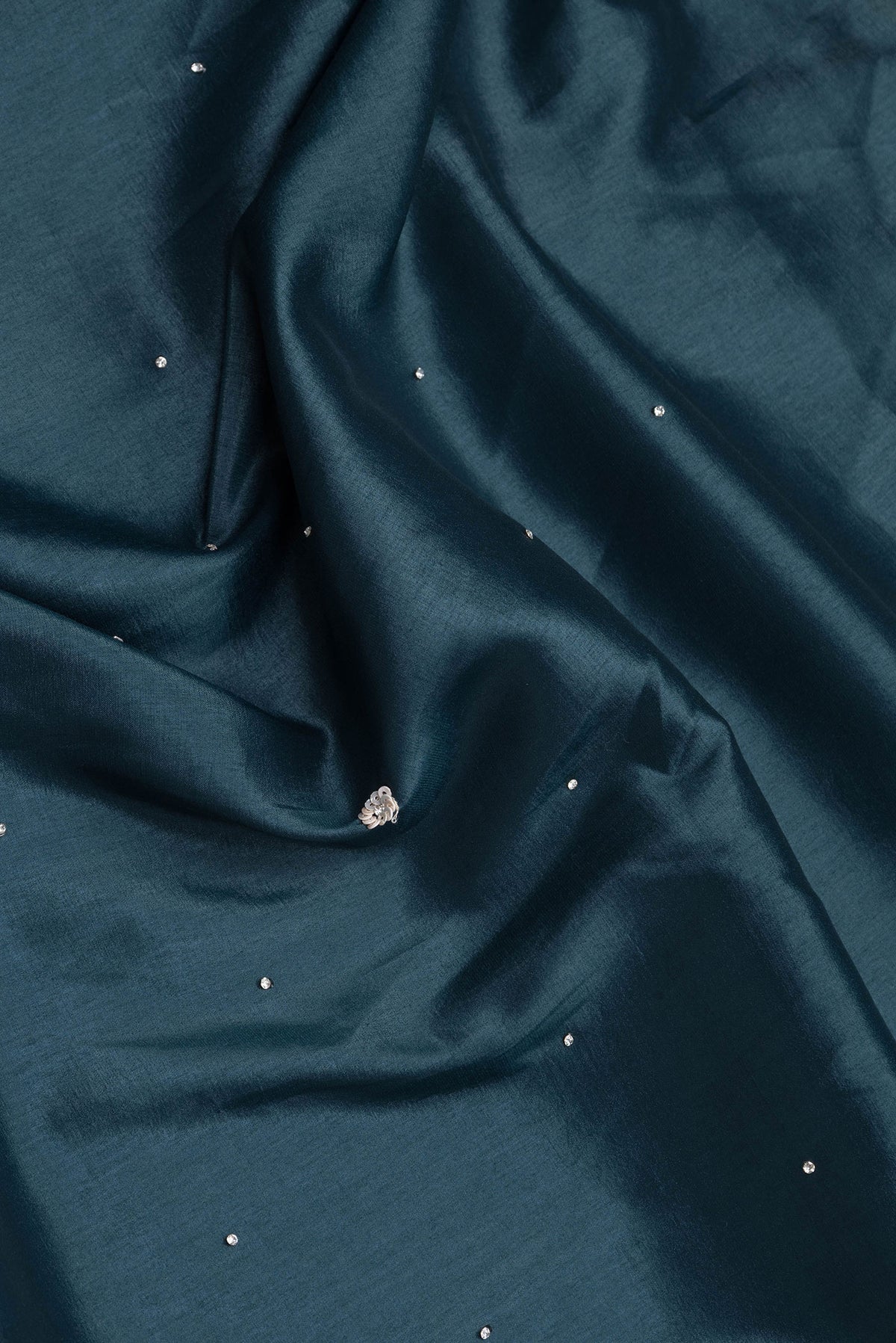 Close up of Peacock Blue Dual Tone Mysore Crepe Saree with Embroidery on the body and Embroidery Border.  displaying folds