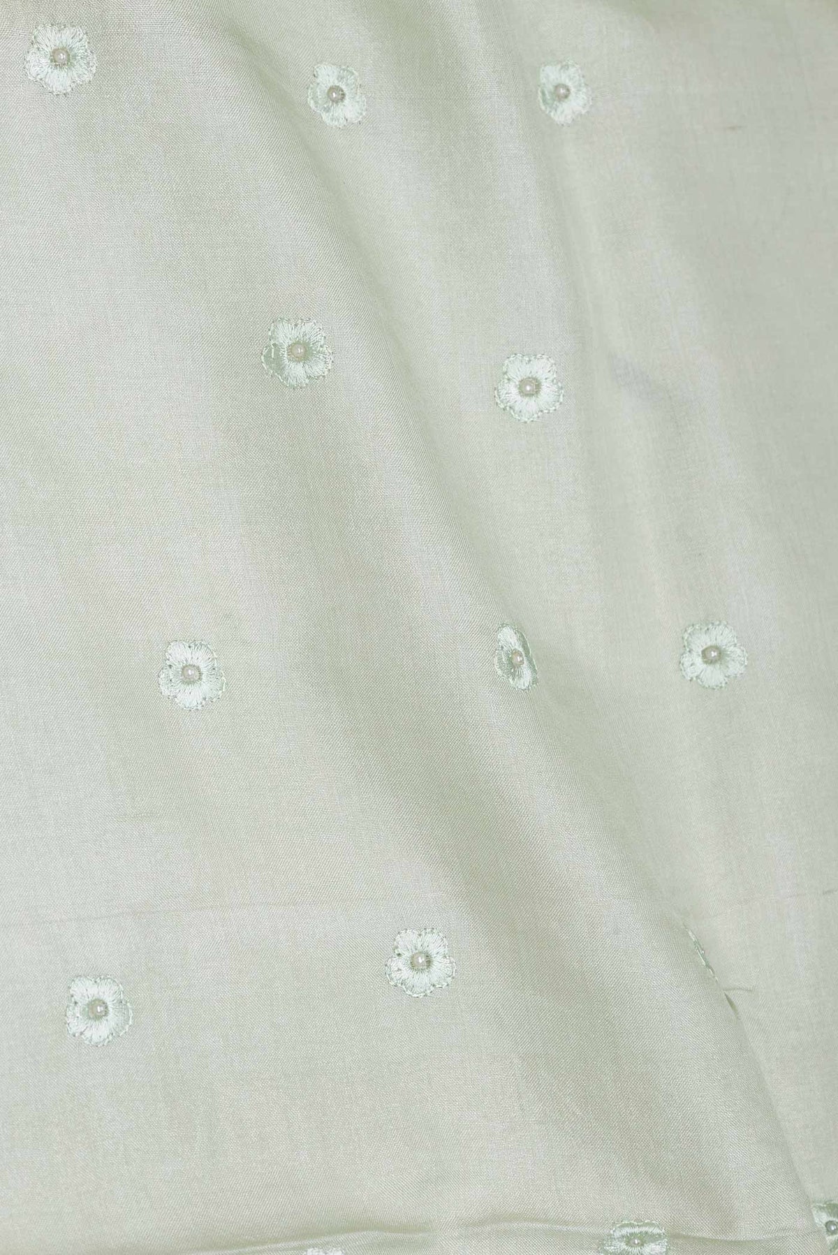 Close up of Pista Green Dual Tone Tussar Saree with Embroidery on the body and Embroidery Border displaying folds