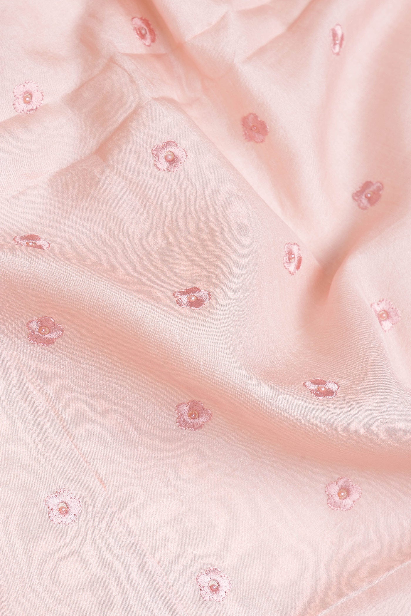 Close up of Rose Gold Dual Tone Tussar Silk Saree with Embroidery on the body and Embroidery Border.  displaying folds