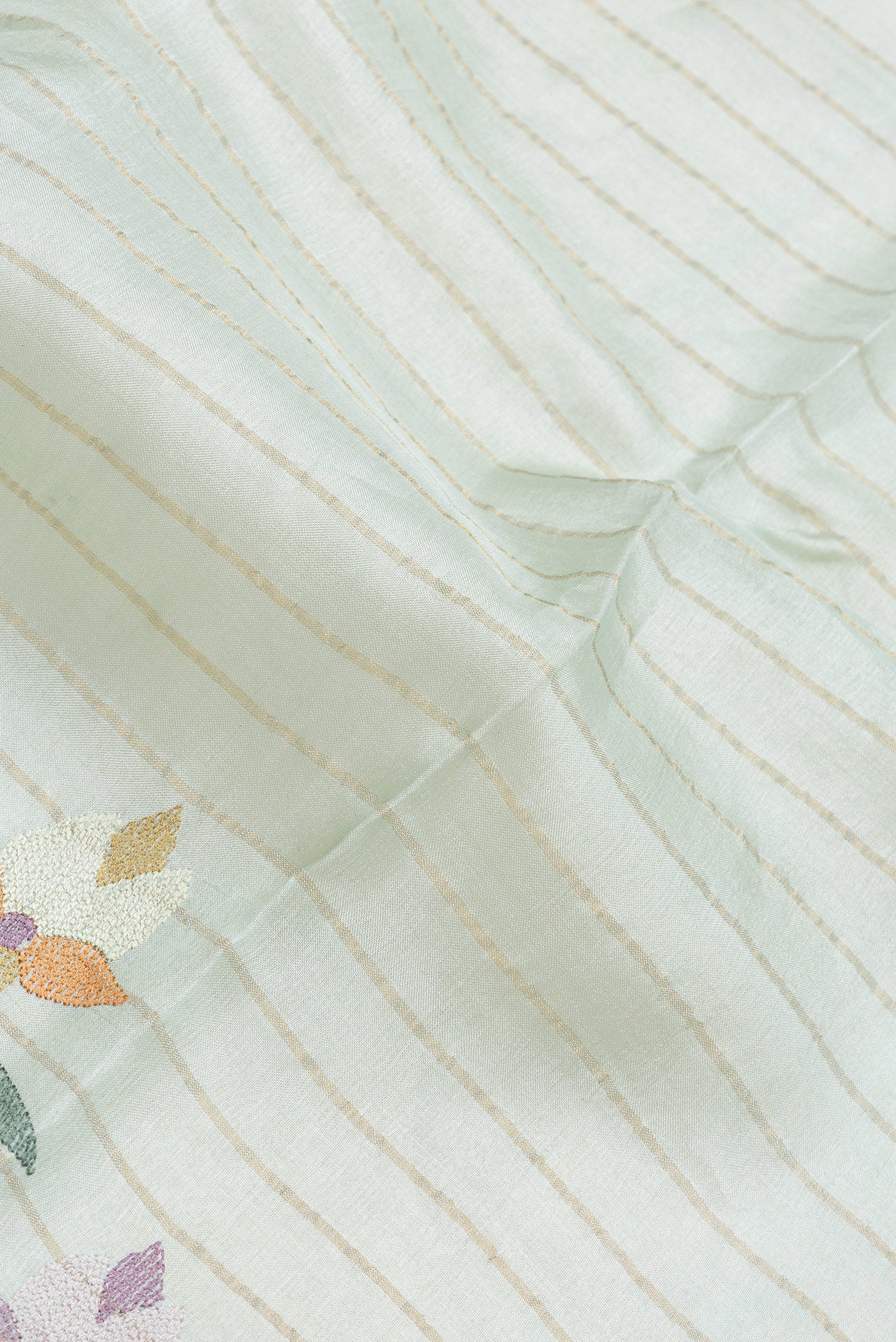 Close up of Sea Green Dual Tone Tussar Silk Saree with Stripes on the body and Embroidery Border.  displaying folds