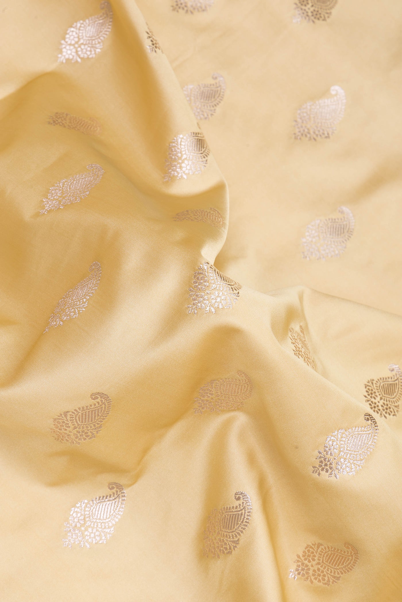 Close up of Sandal Blended Banarasi Silk Saree with Zari Butta on the body and Zari Border.  displaying folds