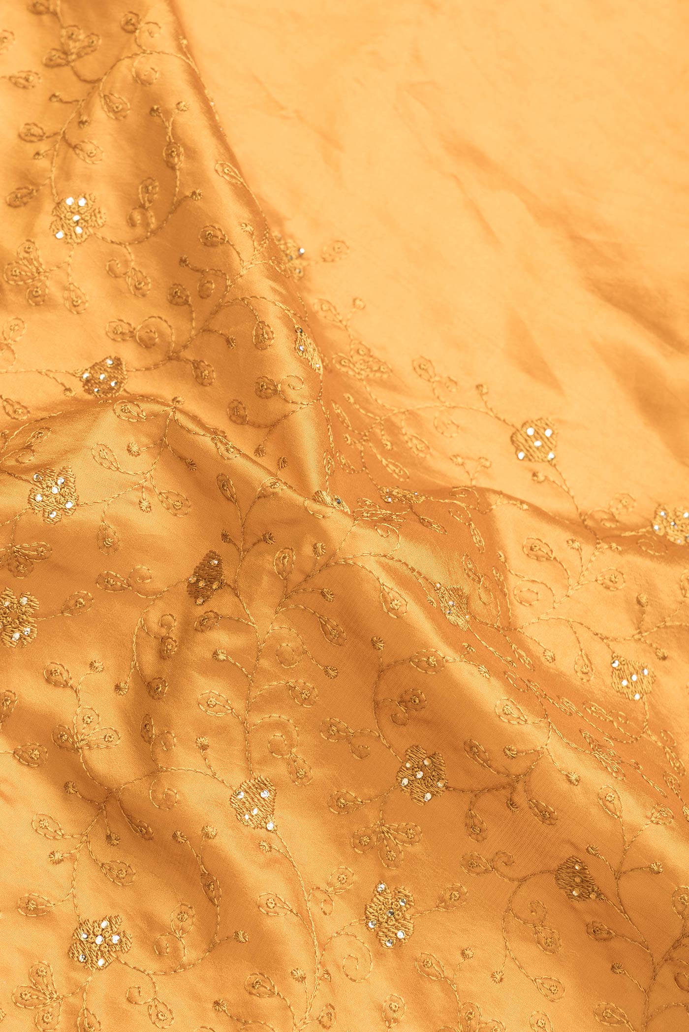 Close up of Mustard Dual Tone Tussar Silk Saree with Embroidery on the body and Embroidery Border.  displaying folds