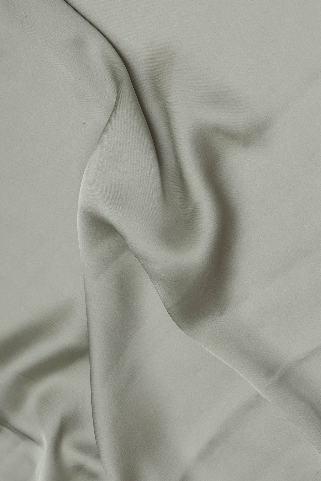 Close up of Sage Green Blended Satin Crepe Saree with Plain Body and Sequin Border.  displaying folds