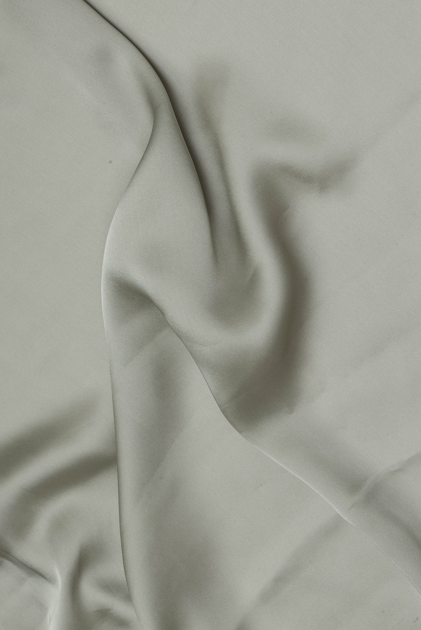 Close up of Sage Green Blended Satin Crepe Saree with Plain Body and Sequin Border.  displaying folds