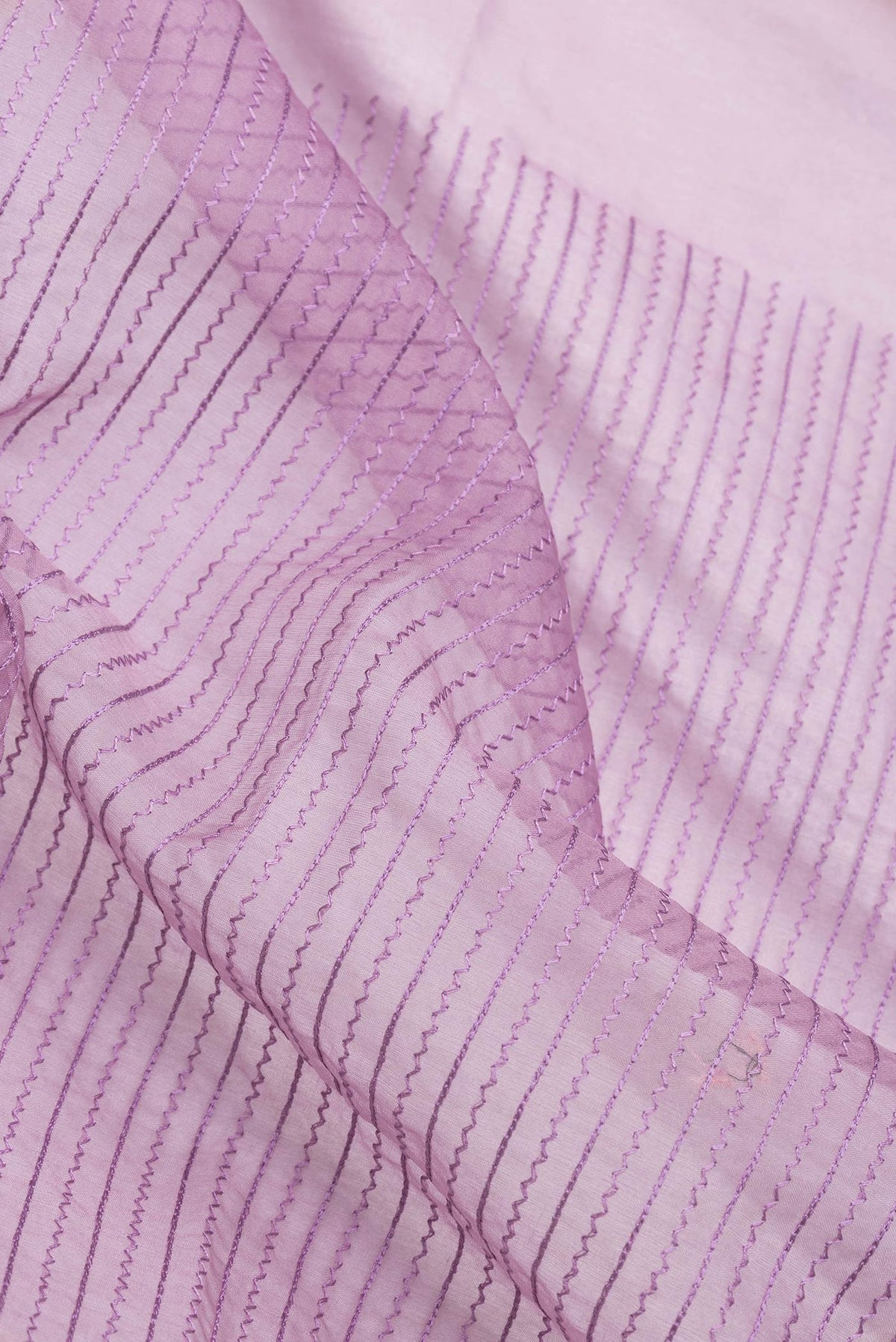 Close up of Pink Dual Tone Organza Silk Saree with Stripes on the body and Embroidery Border.  displaying folds