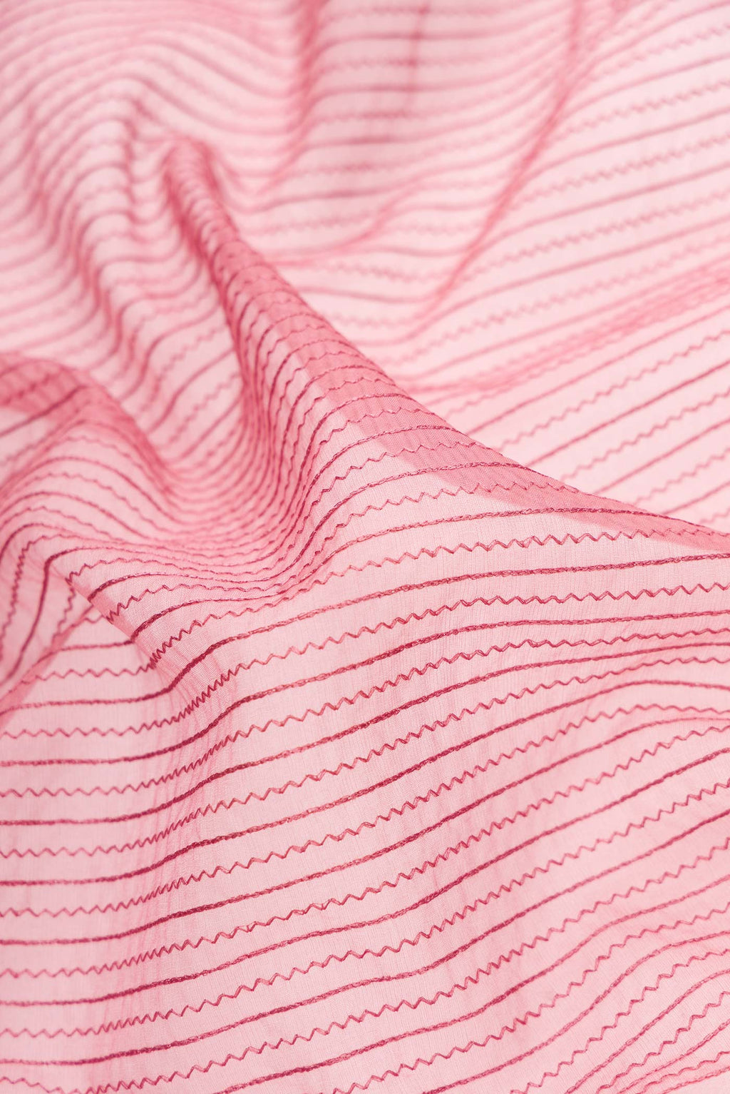 Close up of Pink Dual Tone Organza Silk Saree with Embroidery on the body and Embroidery Border.  displaying folds