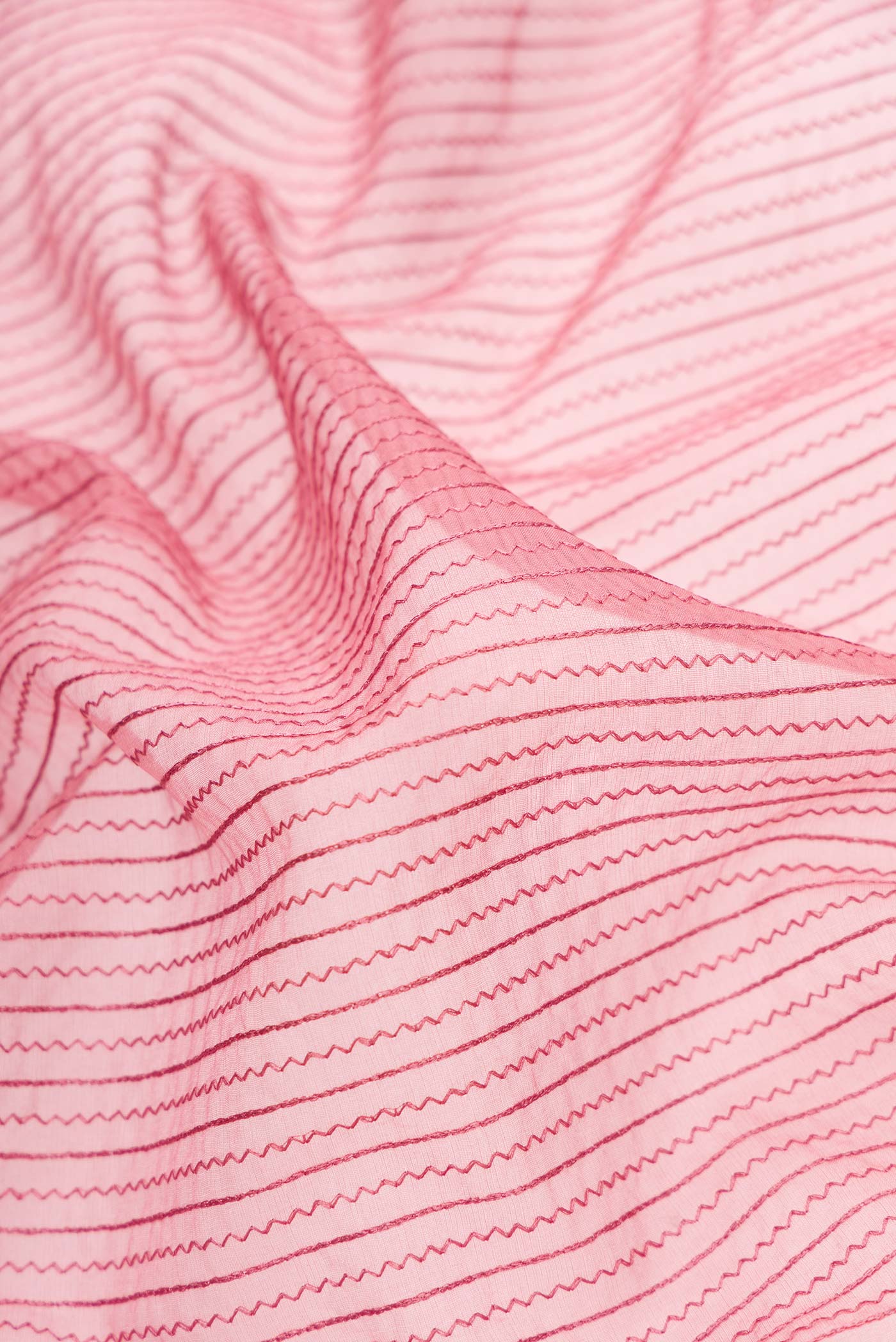 Close up of Pink Dual Tone Organza Silk Saree with Embroidery on the body and Embroidery Border.  displaying folds