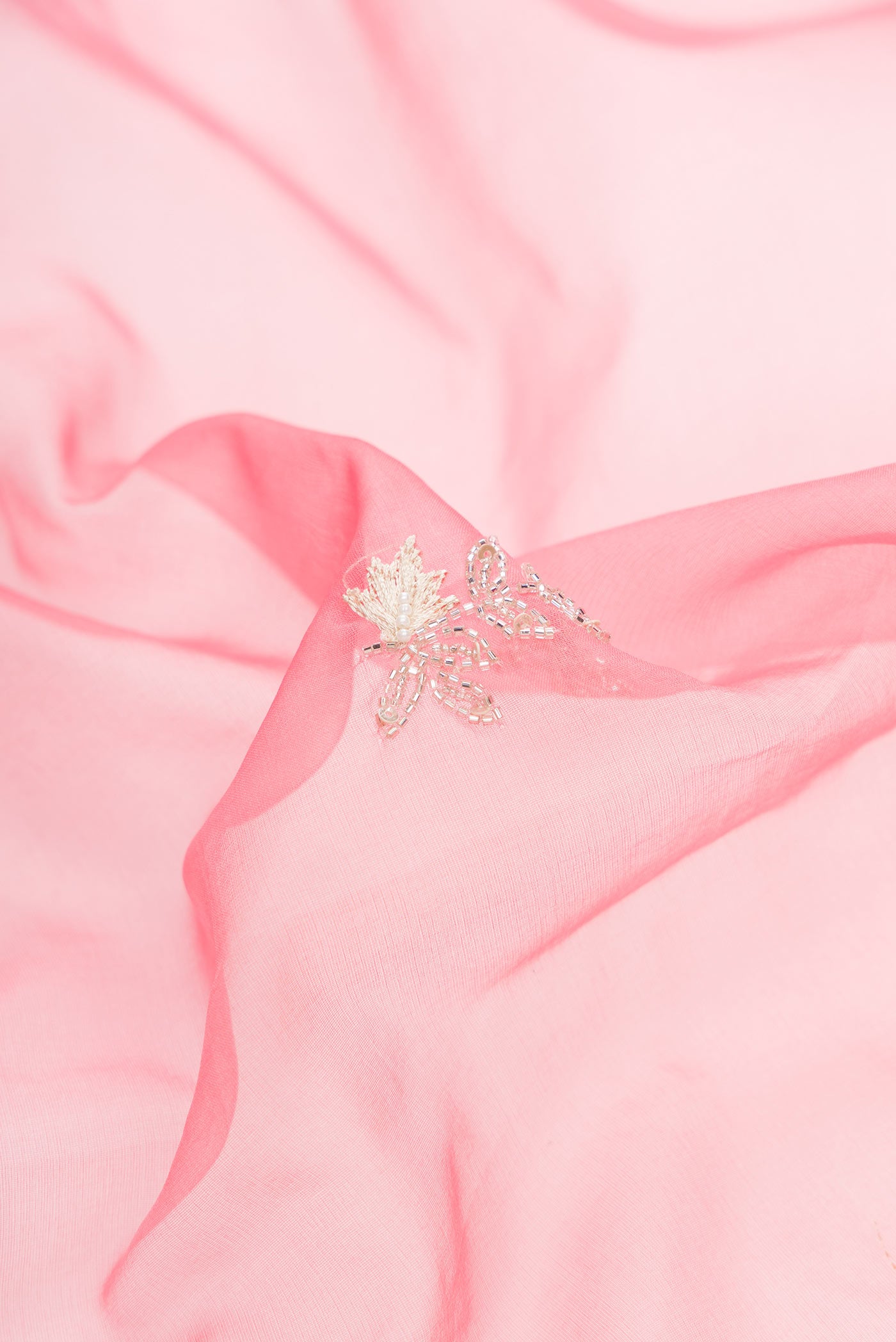 Close up of Pink Dual Tone Organza Silk Saree with Embroidery on the body and Embroidery Border.  displaying folds