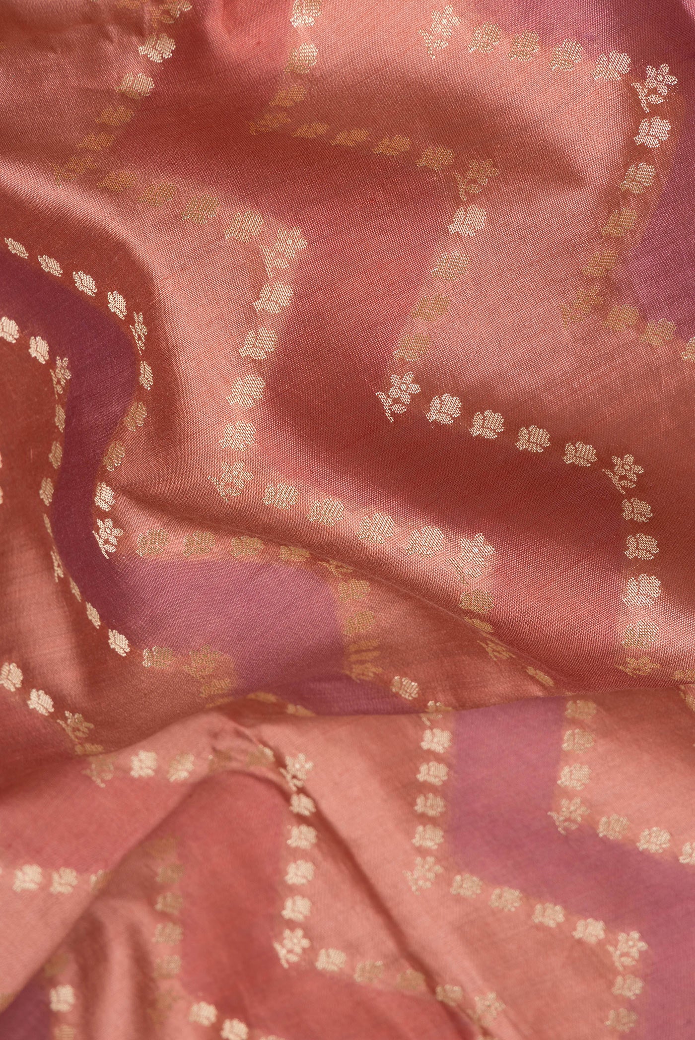 Close up of Peach Tussar Silk Saree with Zari Butta on the body and Zari Border.  displaying folds