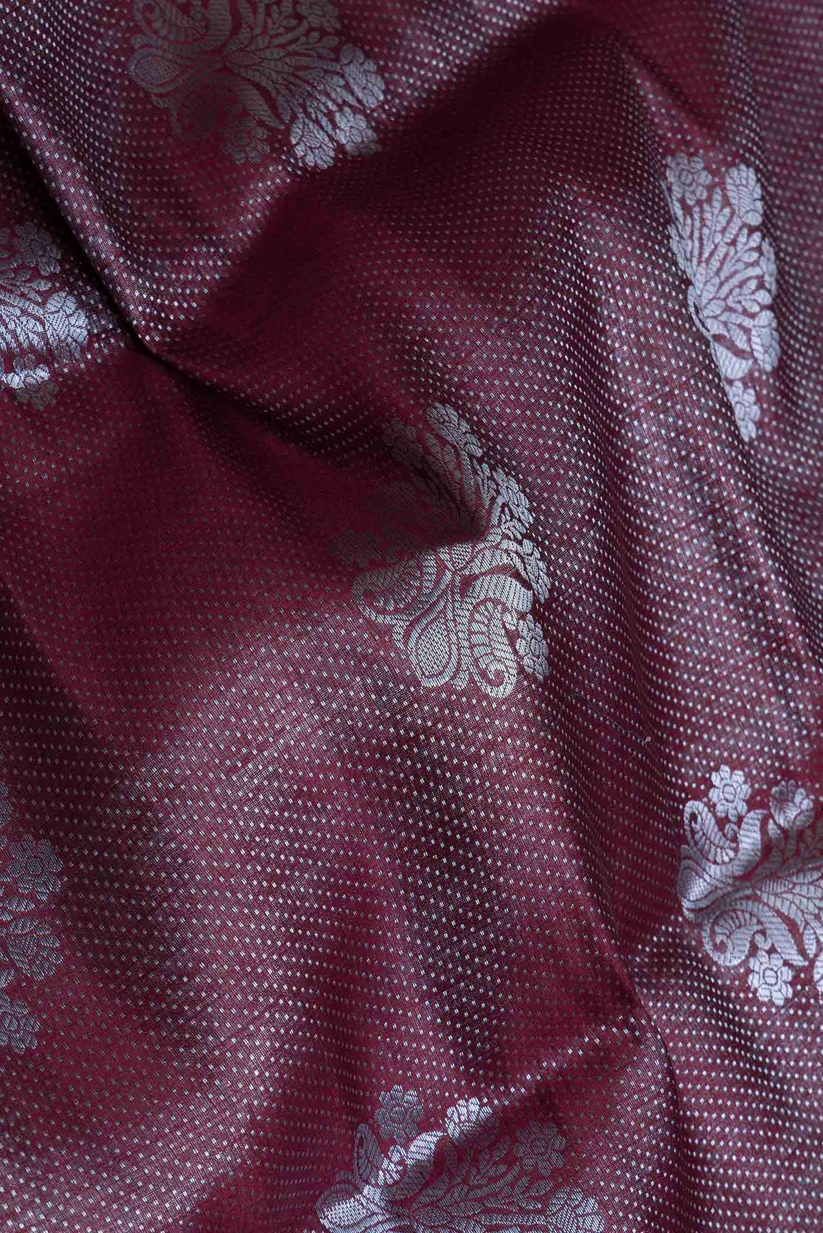 Close up of Burgundy Banarasi Raw Silk Saree with Zari Brocade on the body and Zari Border displaying folds