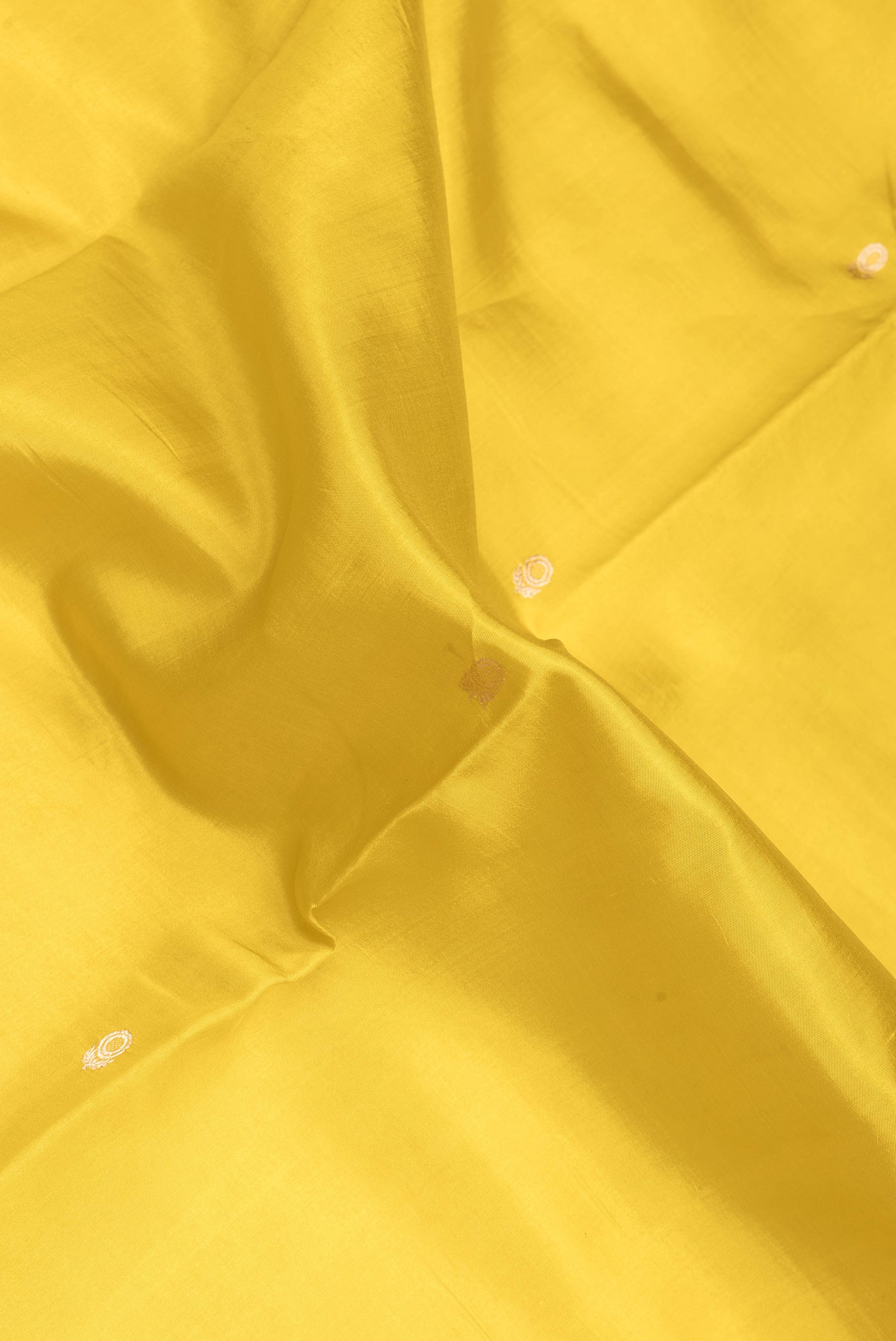 Close up of Yellow Dual Tone Tussar Silk Saree with Zari Butta on the body and Fancy Border.  displaying folds