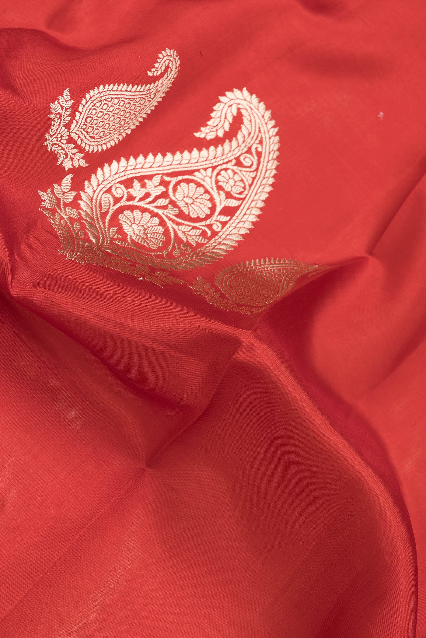 Close up of Red Dual Tone Tussar Silk Saree with Zari Butta on the body and Without Border.  displaying folds
