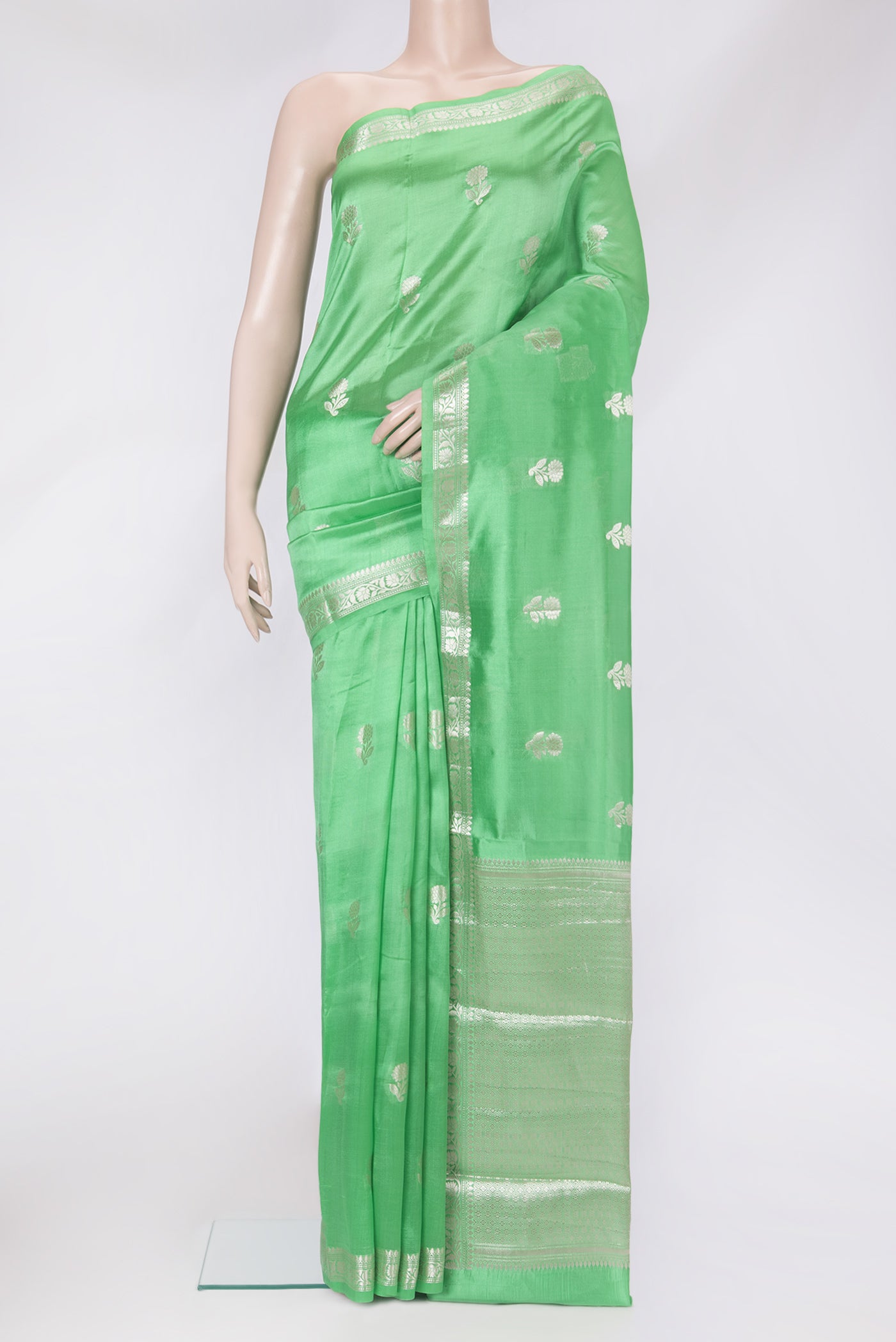 Green Tussar Silk Saree with Zari Butta on the body and Zari Border.  displayed on a mannequin