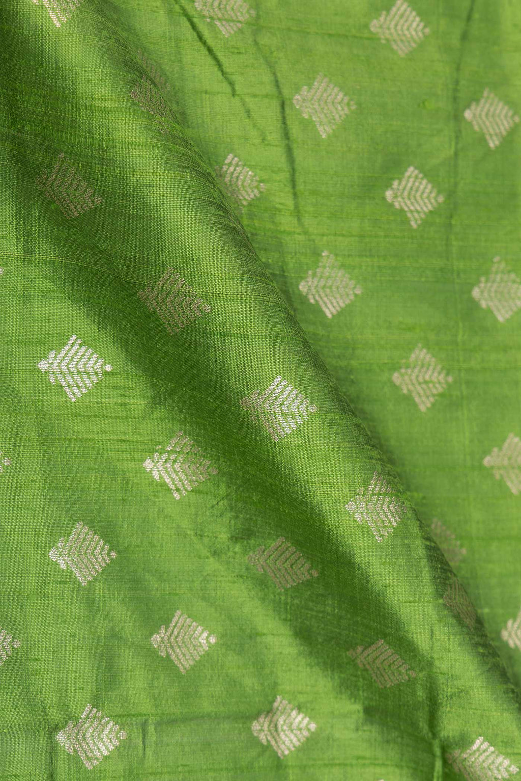 Close up of Parrot Green Dual Tone Raw Silk Saree with Zari Brocade on the body and Zari Border displaying folds