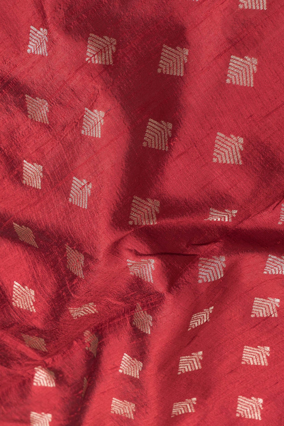 Close up of Maroon Dual Tone Raw Silk Saree with Zari Butta on the body and Zari Border.  displaying folds