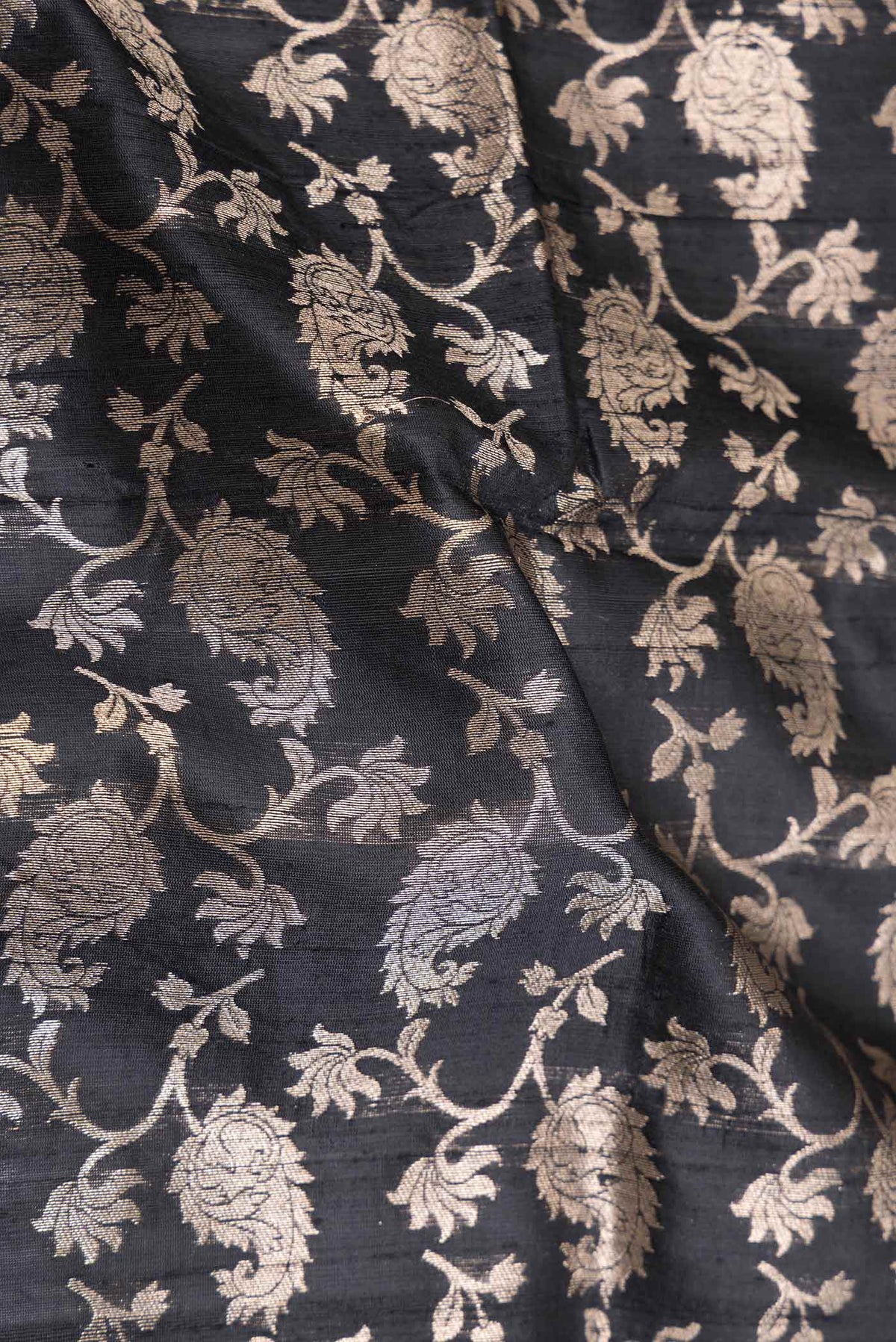 Close up of Black Dual Tone Raw Silk Saree with Zari Brocade on the body and Zari Border displaying folds