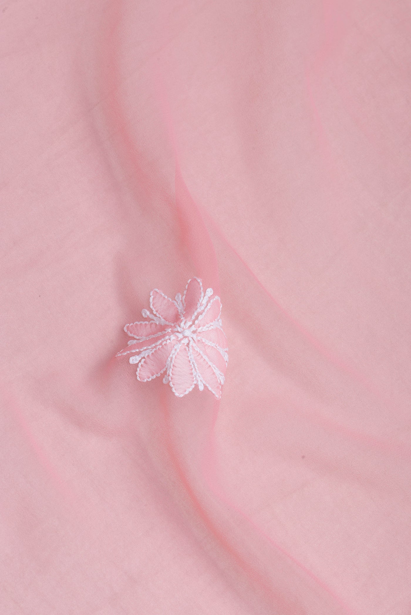 Close up of Rose pink Georgette Saree with Embroidery on the body and Embroidery Border.  displaying folds