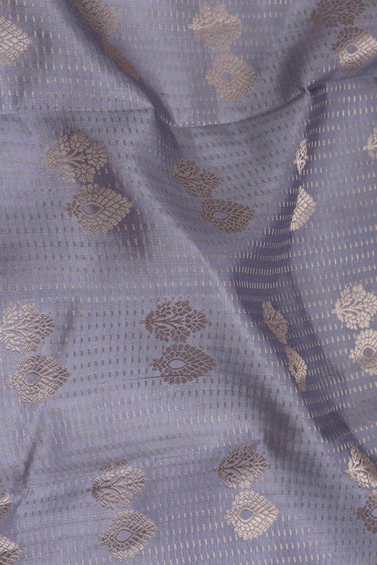 Close up of Lilac Banarasi Raw Silk Saree with Zari Butta on the body and Zari Border displaying folds