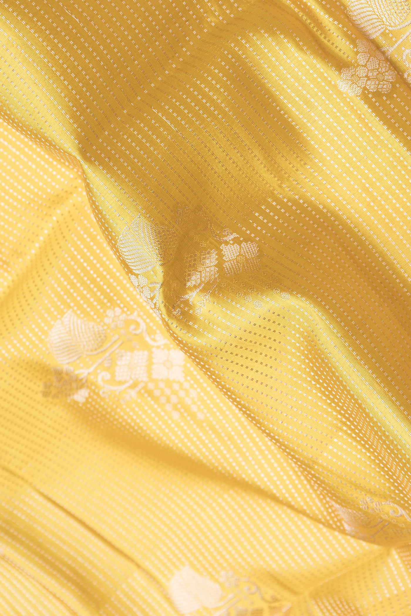Close up of Yellow Dual Tone Tussar Silk Saree with Zari Brocade on the body and Fancy Border.  displaying folds