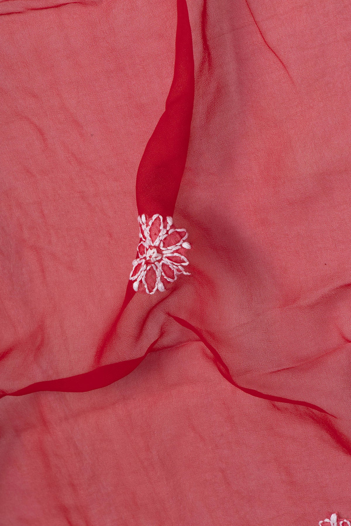 Close up of Red Georgette Saree with Embroidery on the body and Embroidery Border.  displaying folds