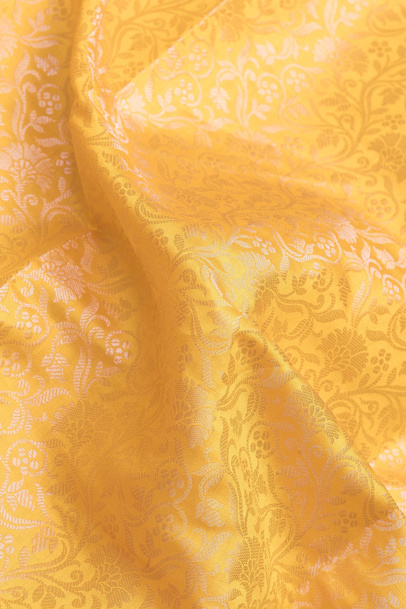 Close up of Yellow Dual Tone Banarasi Raw Silk Saree with Zari Brocade on the body and Zari Border.  displaying folds