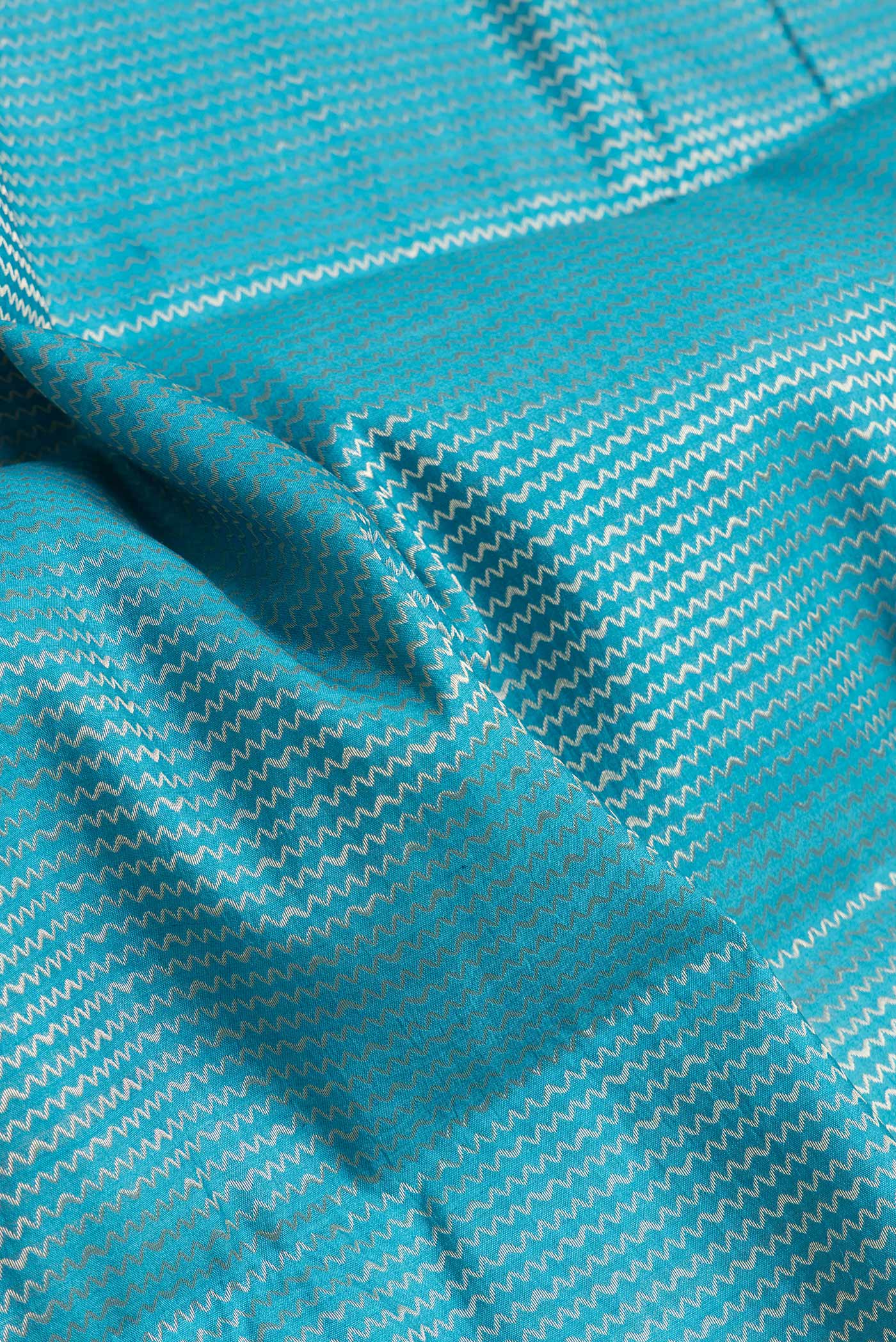 Close up of Sky Blue Dual Tone Tussar Silk Saree with Zari Brocade on the body and Zari Border.  displaying folds