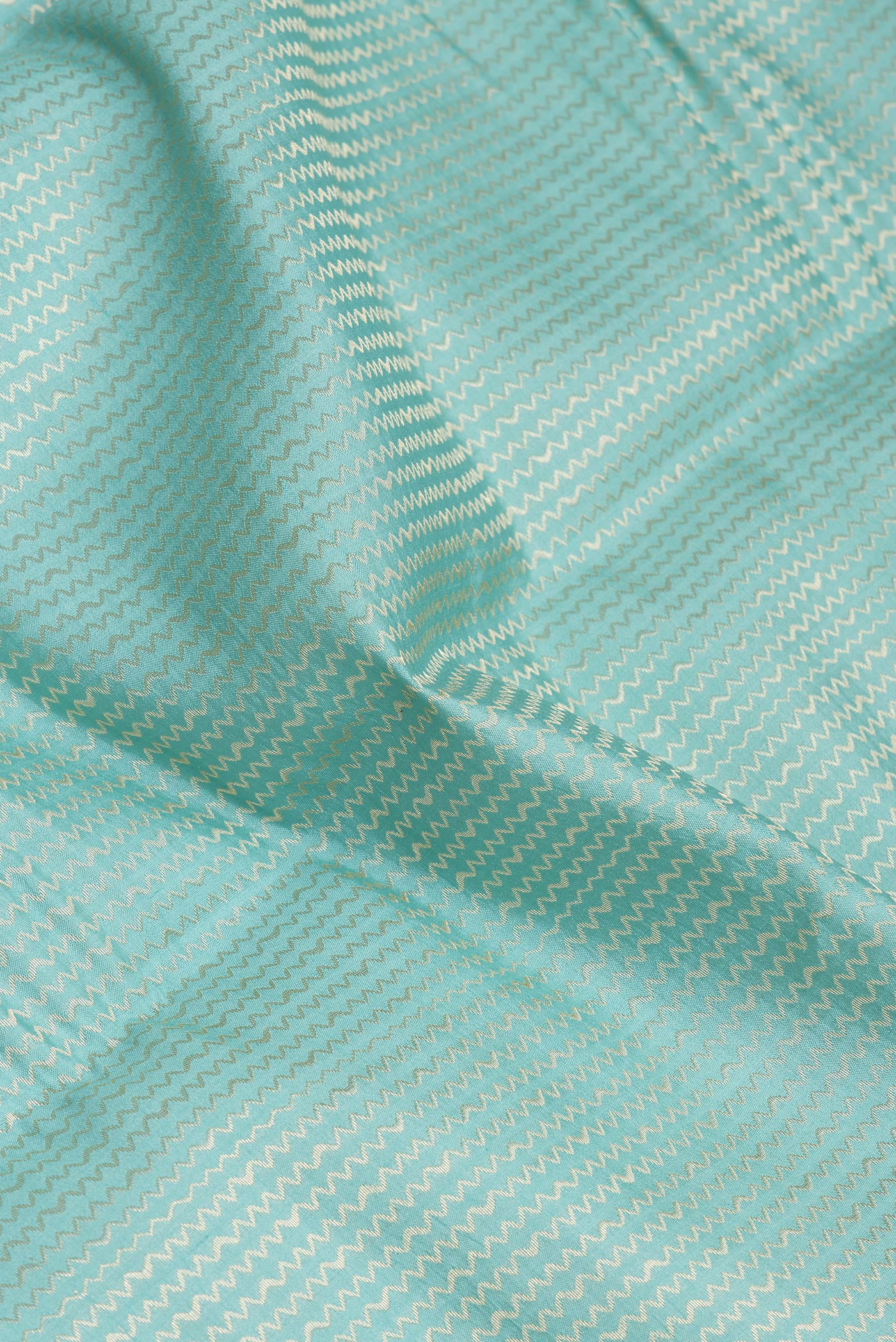 Close up of Sky Blue Dual Tone Tussar Silk Saree with Zari Brocade on the body and Zari Border.  displaying folds