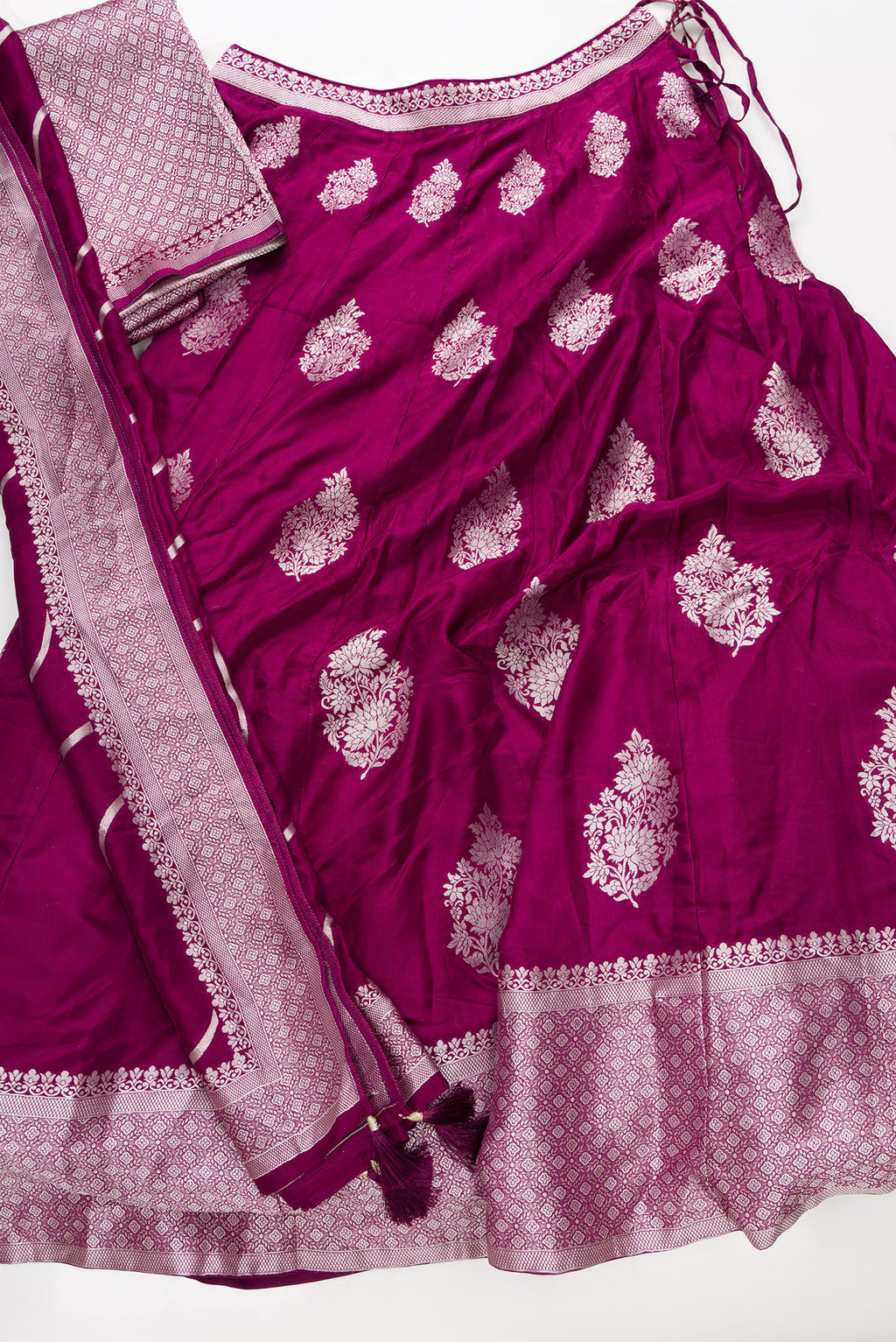 Flat lay of Burgundy Banarasi Silk Womens Lehenga set featuring Zari Brocade Choli paired with Burgundy Zari Brocade Skirt with Zari Border and a Zari Butta dupatta in Burgundy