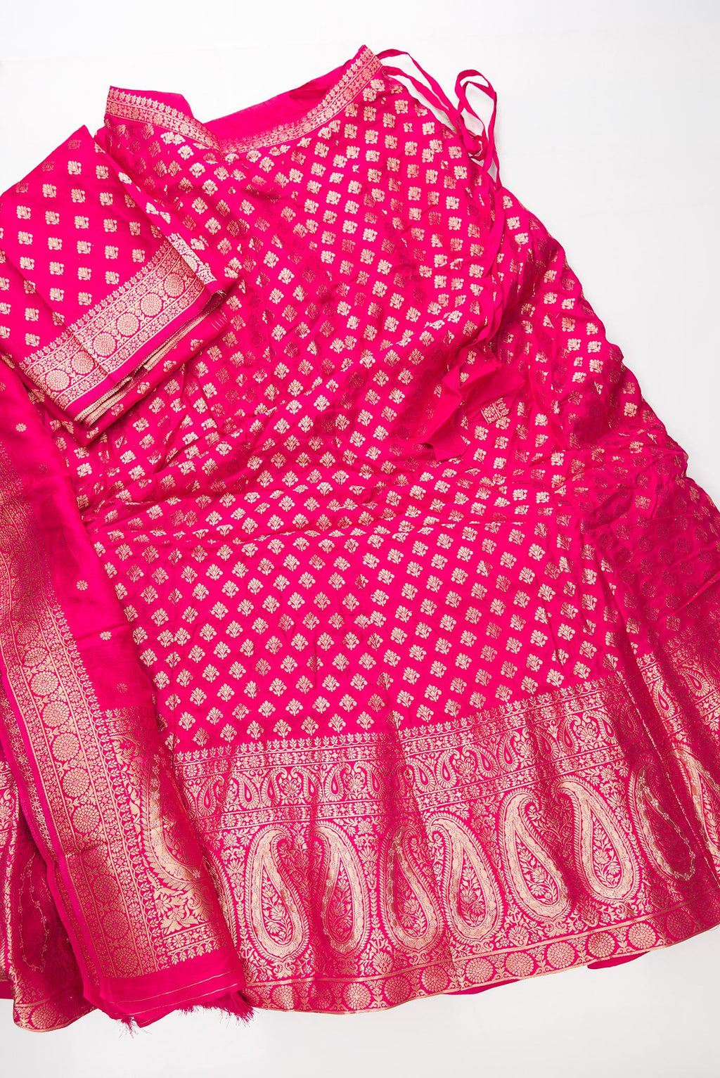 Flat lay of Dark Pink Banarasi Silk Womens Lehenga set featuring Zari Brocade Choli paired with Dark Pink Zari Brocade Skirt with Zari Border and a Zari Butta dupatta in Dark Pink