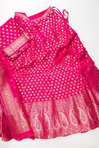 Flat lay of Dark Pink Banarasi Silk Womens Lehenga set featuring Zari Brocade Choli paired with Dark Pink Zari Brocade Skirt with Zari Border and a Zari Butta dupatta in Dark Pink
