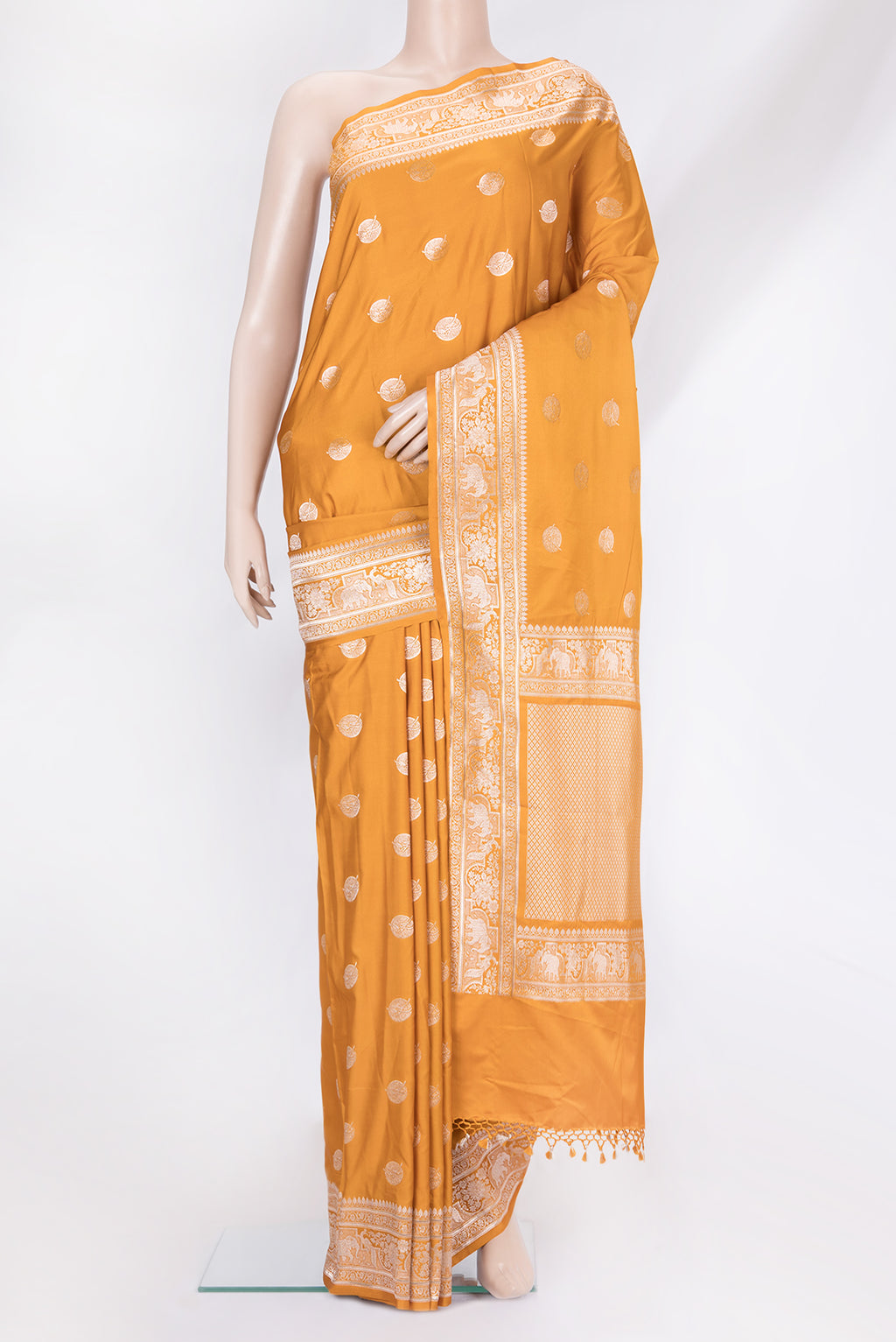 Mustard Banarasi Silk Saree with Zari Butta on the body and Zari Border.  displayed on a mannequin