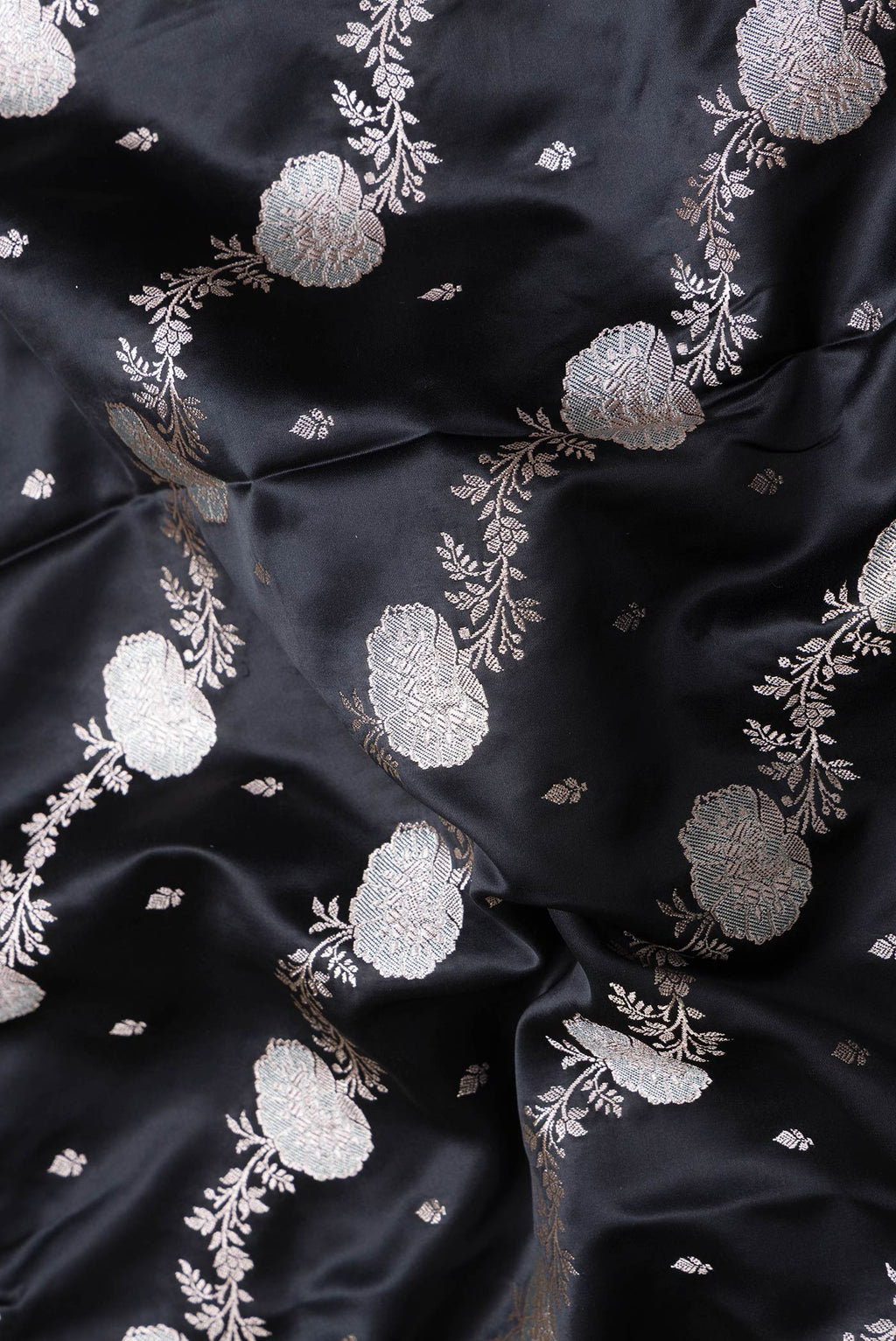 Close up of Black Dual Tone Banarasi Silk Saree with Zari Butta on the body and Fancy Border.  displaying folds