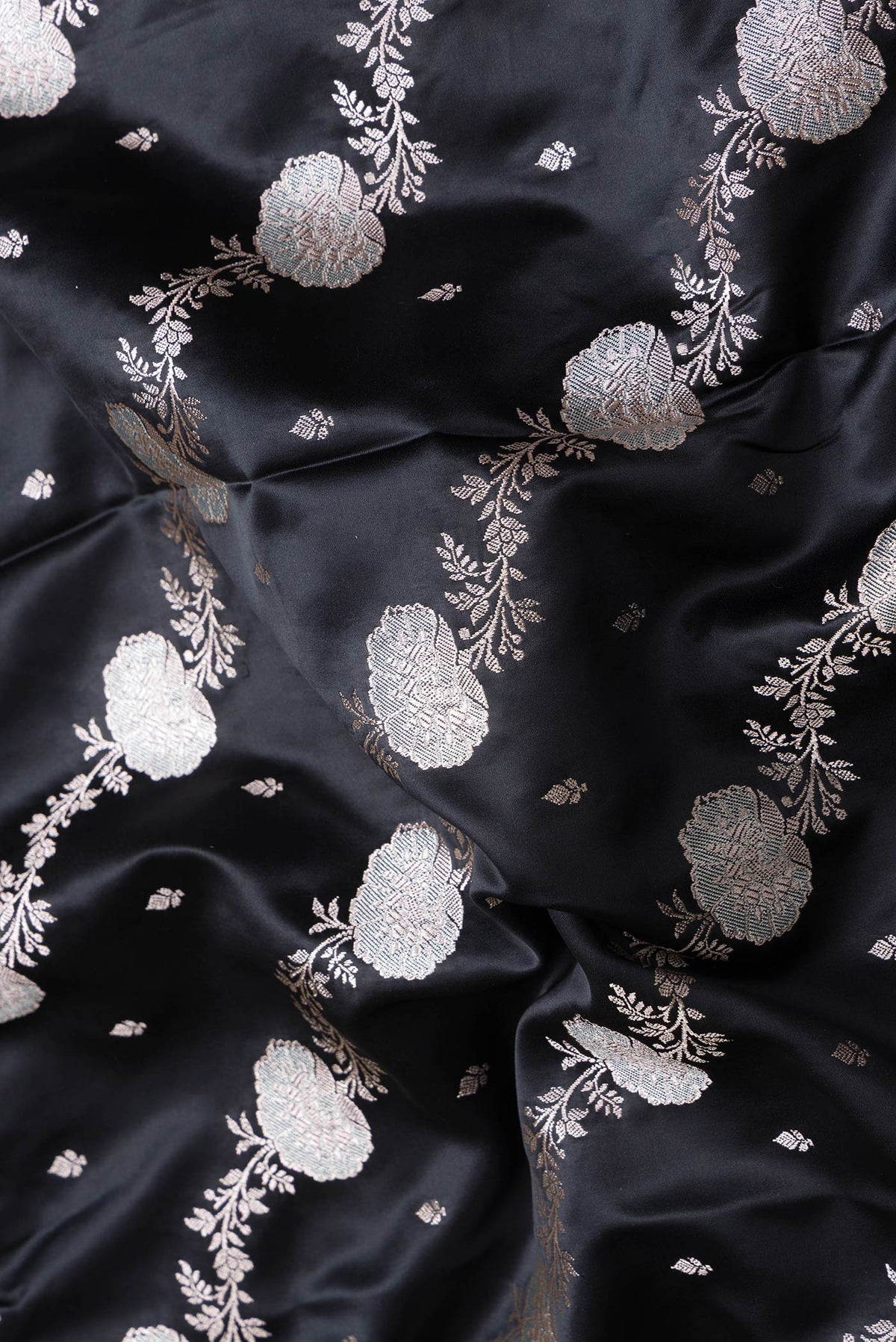 Close up of Black Dual Tone Banarasi Silk Saree with Zari Butta on the body and Fancy Border.  displaying folds