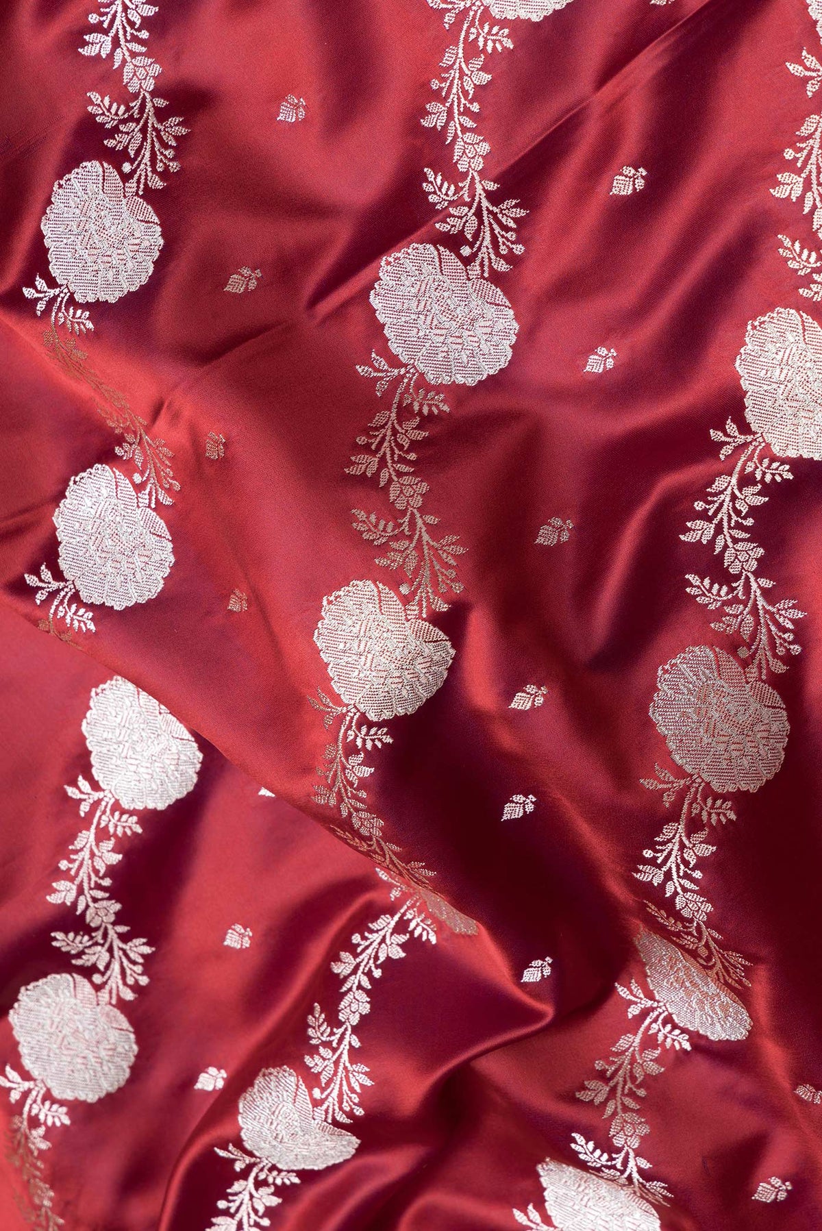 Close up of Maroon Dual Tone Blended Banarasi Silk Saree with Zari Brocade on the body and Zari Border.  displaying folds