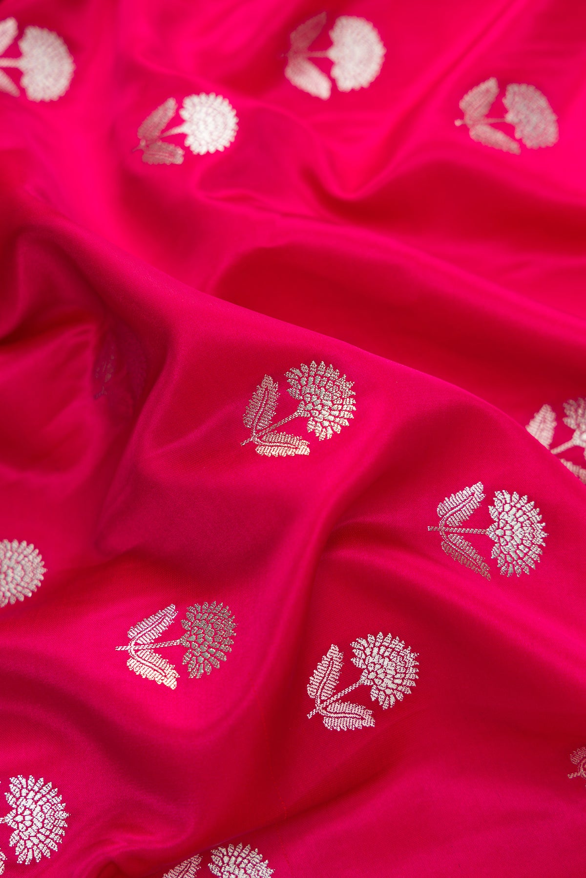 Close up of Dark Pink Dual Tone Blended Banarasi Silk Saree with Zari Butta on the body and Zari Border.  displaying folds