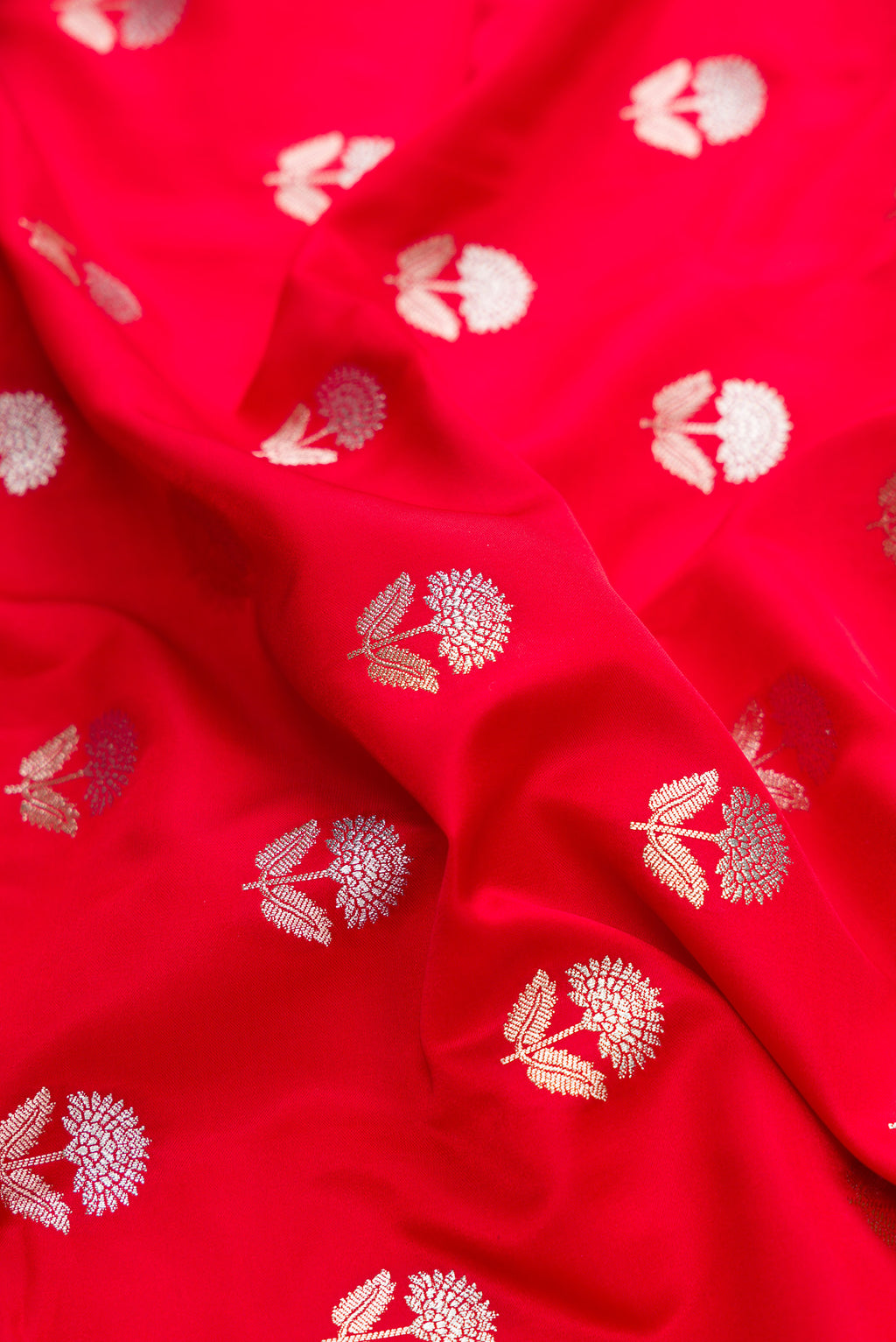Close up of Red Dual Tone Blended Banarasi Silk Saree with Zari Butta on the body and Zari Border.  displaying folds